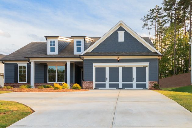 Suburban house with blue-gray siding, two-car garage, and a wide concrete driveway