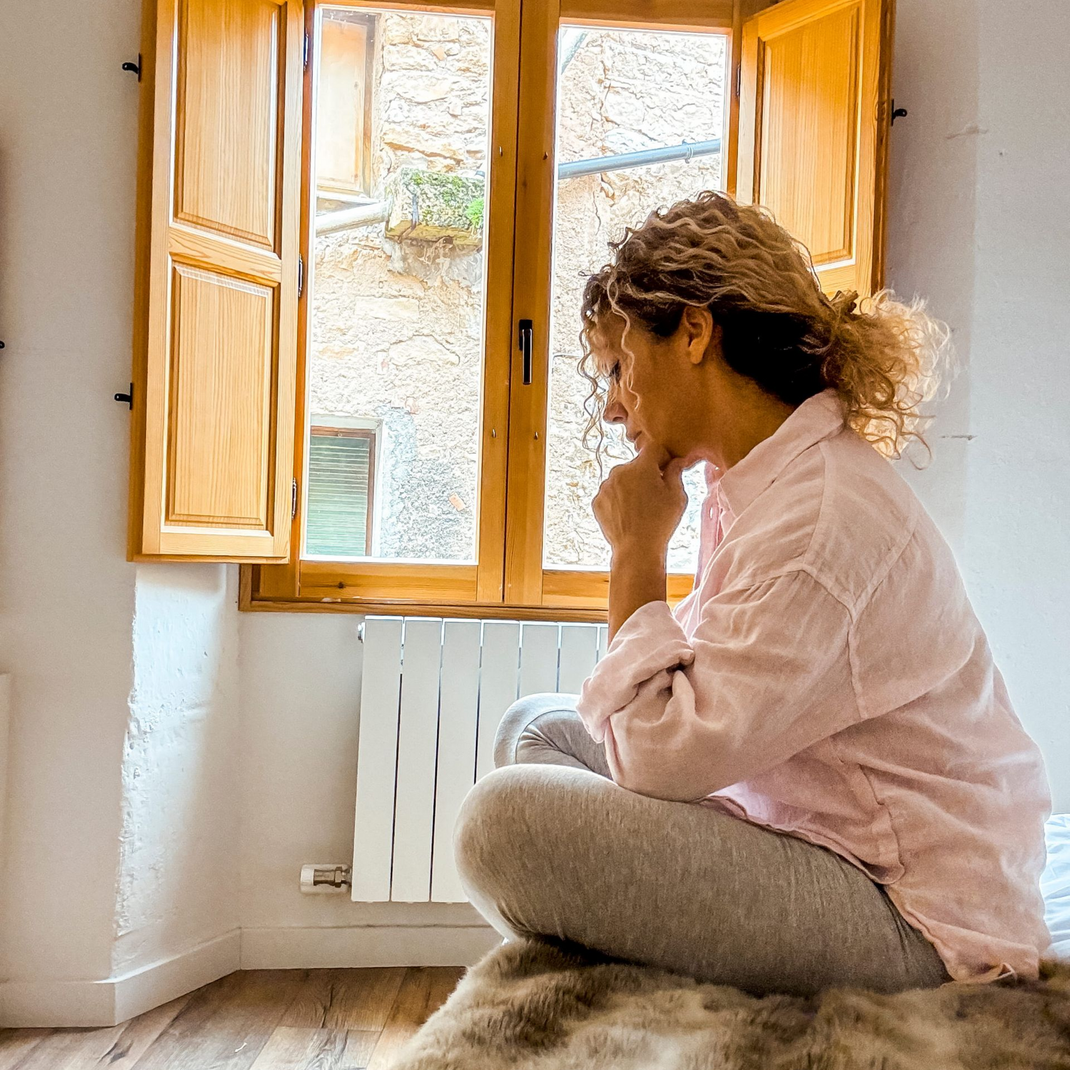 A woman stressing over her academics in her dorm.