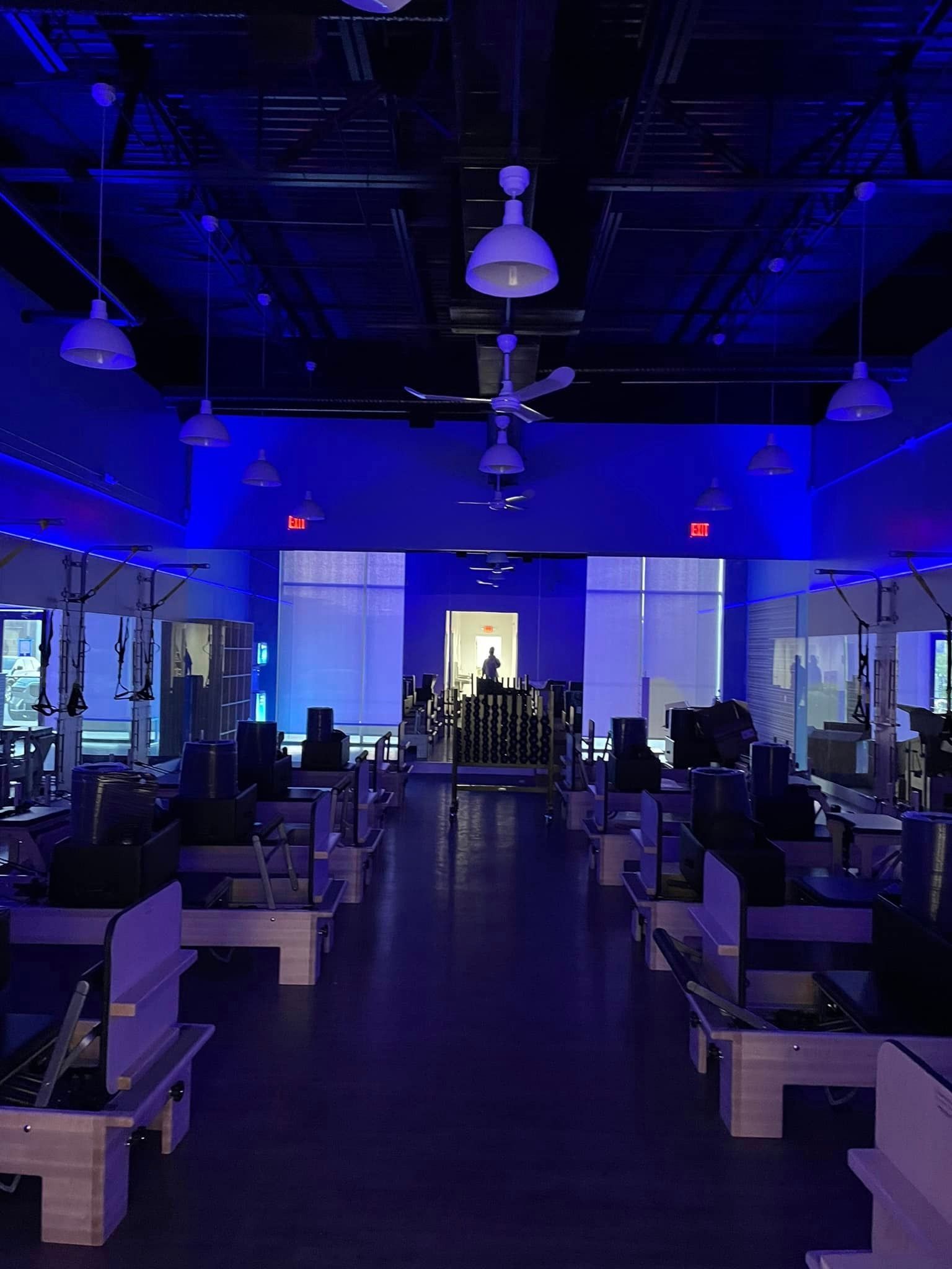 The inside of a gym with blue lights on the ceiling.