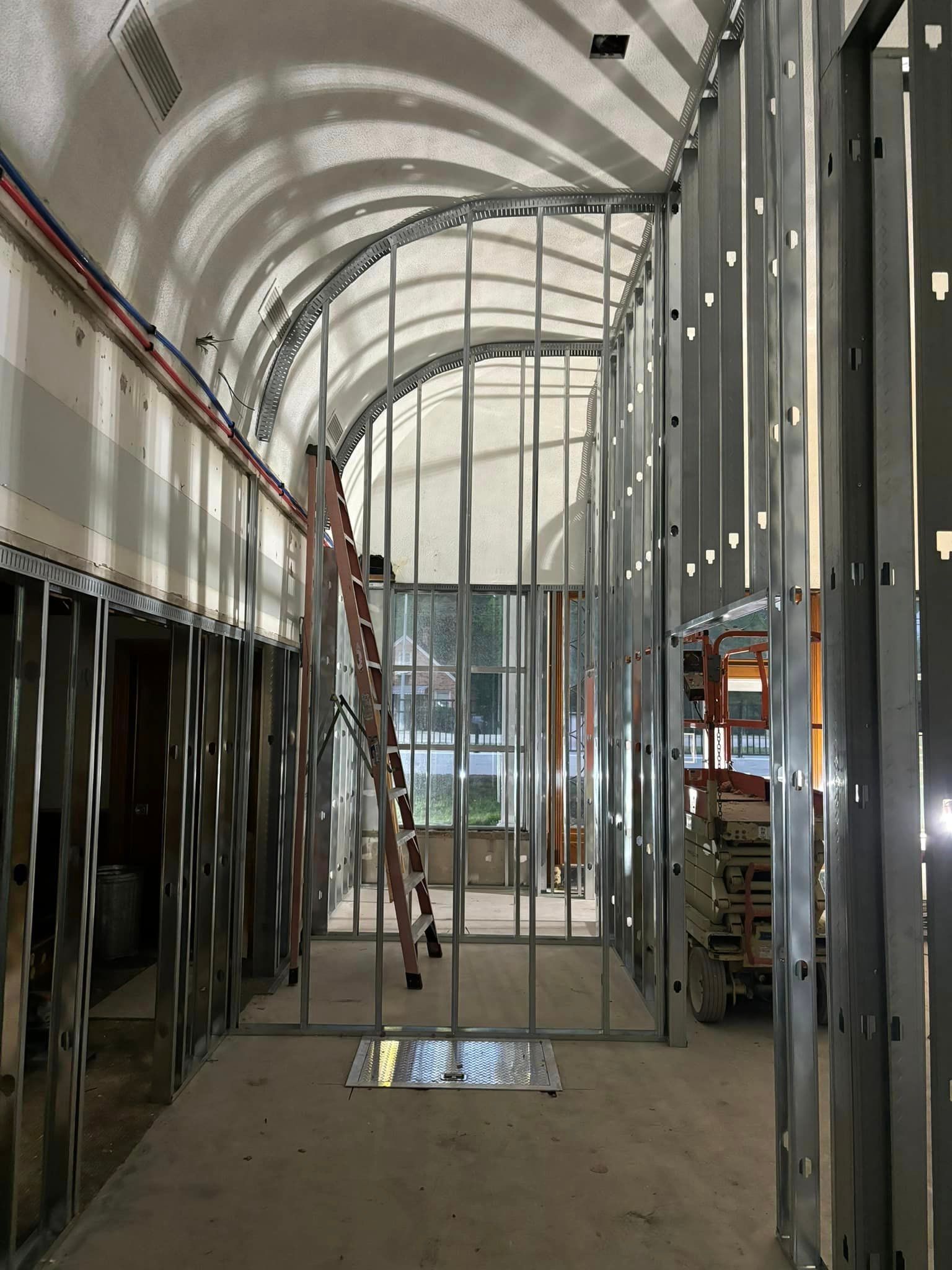A ladder is hanging from the ceiling of a building under construction.