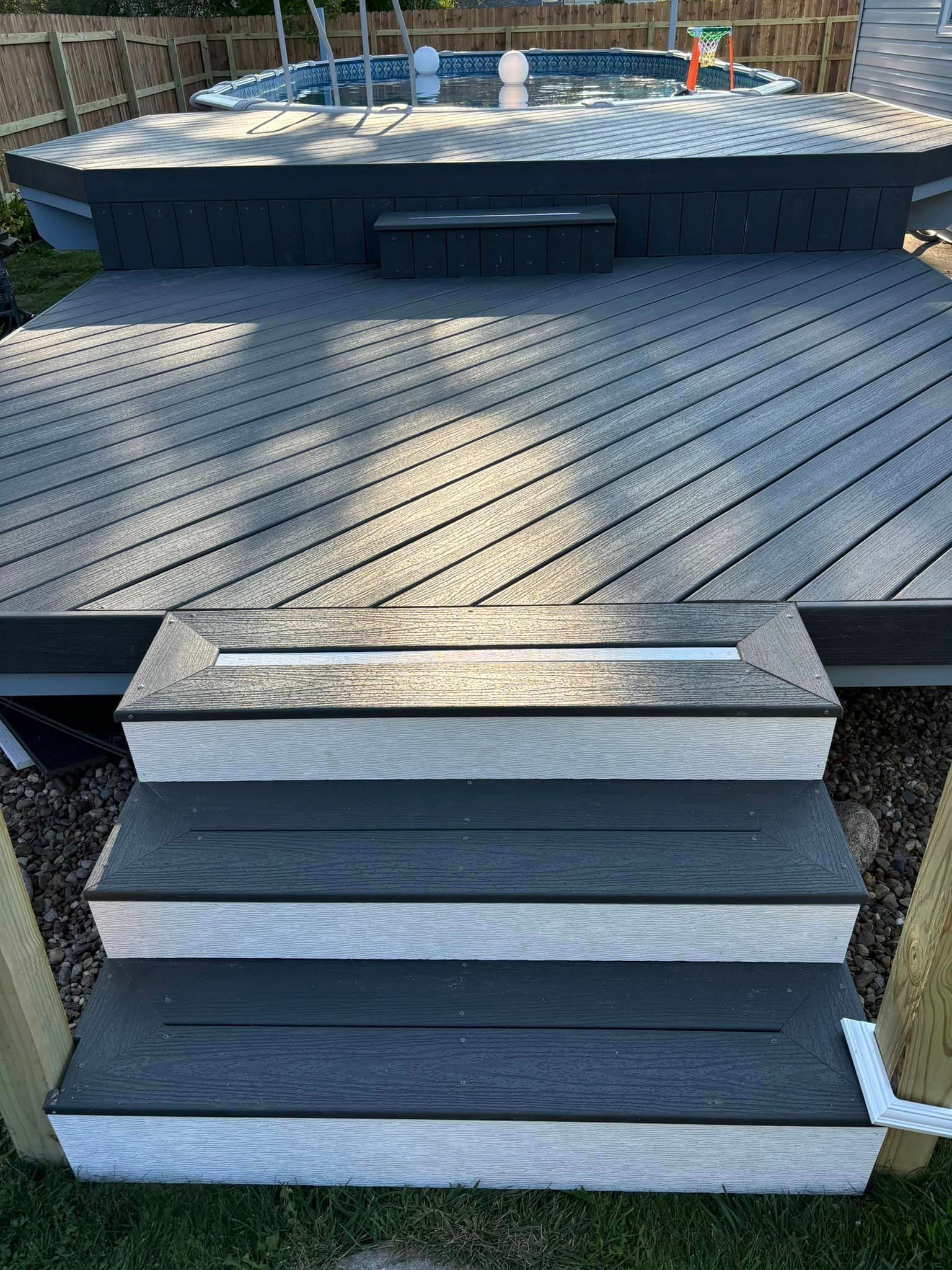 A wooden deck with stairs leading to a swimming pool.