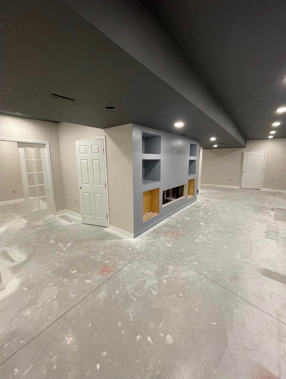 A large empty room with a lot of shelves and doors.