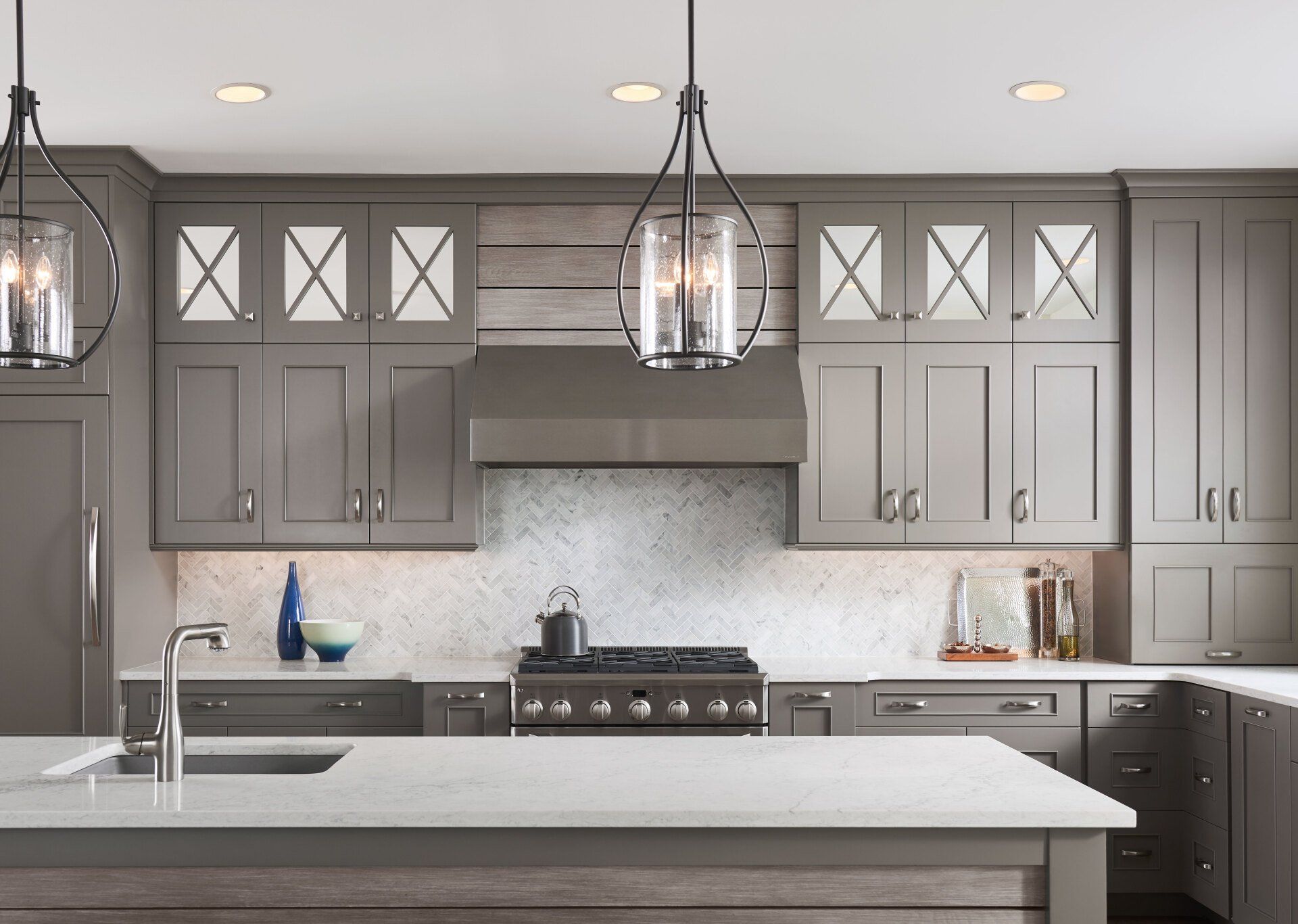 Modern gray kitchen with pendant lights, white countertops, and stainless steel appliances