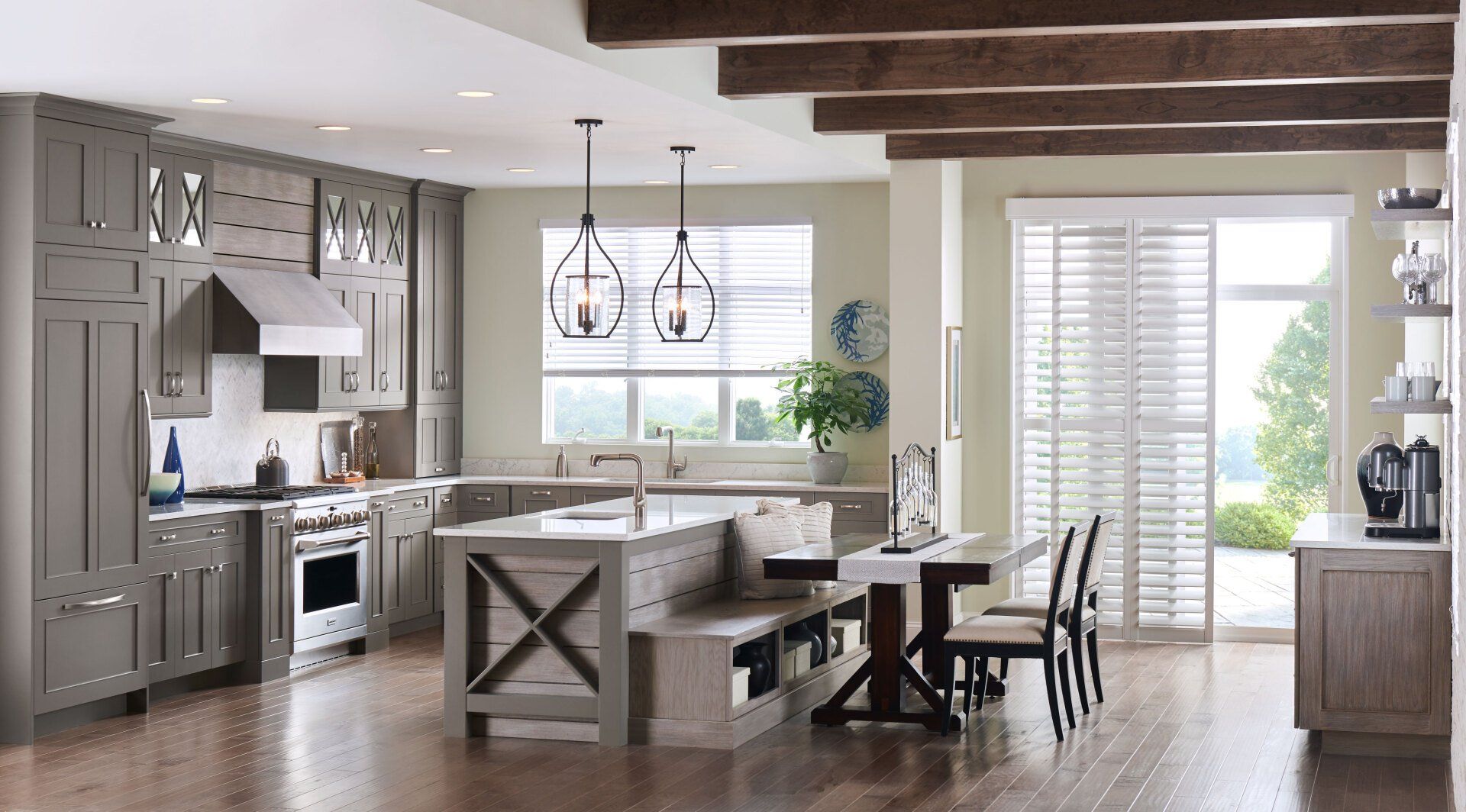 Bright modern kitchen with wood beams, island seating, stainless appliances, and large windows