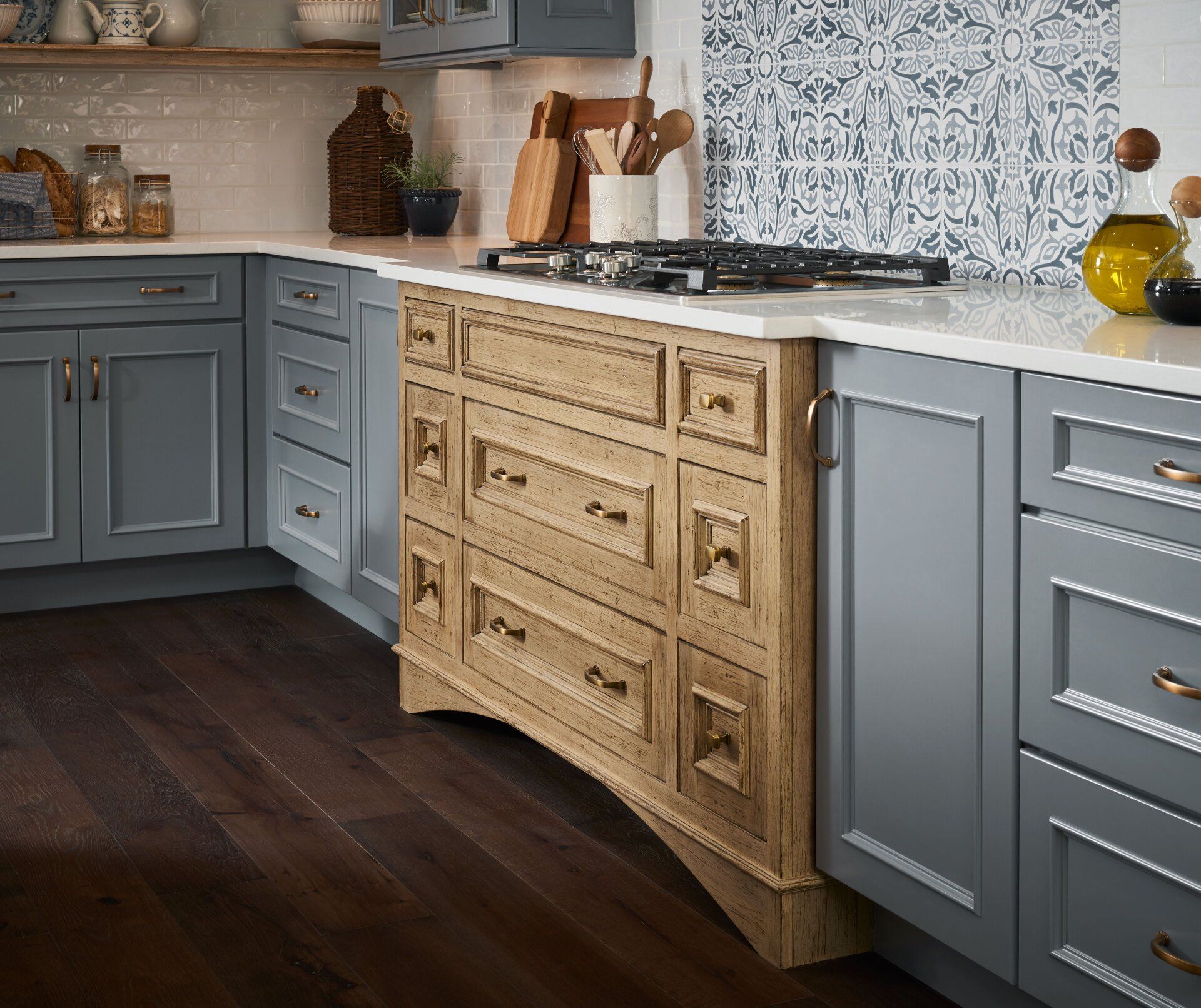Modern kitchen with gray cabinets, wood island drawers, white counters, and dark hardwood flooring