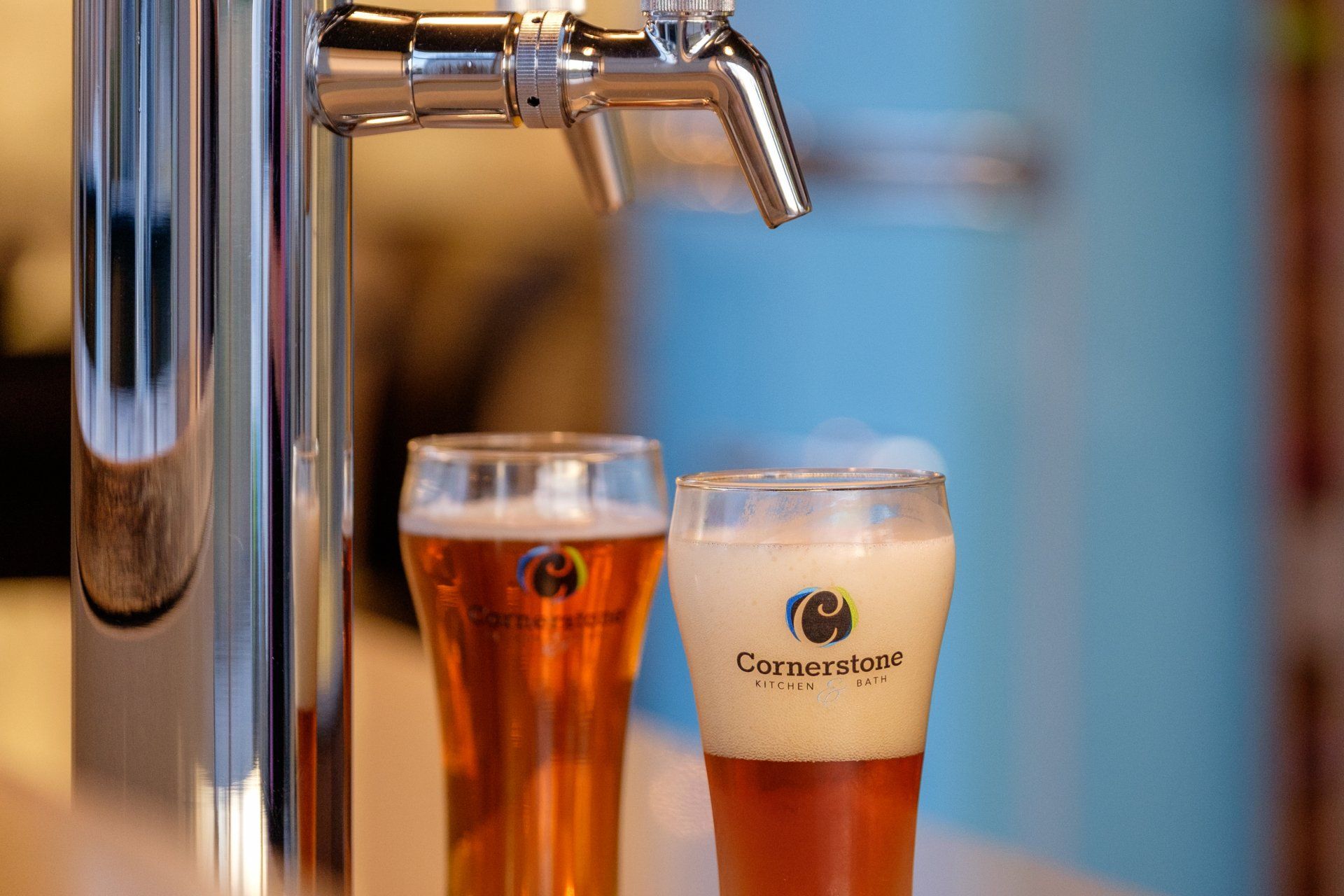 Beer taps filling two glasses of amber beer, one with foam, in a bar setting