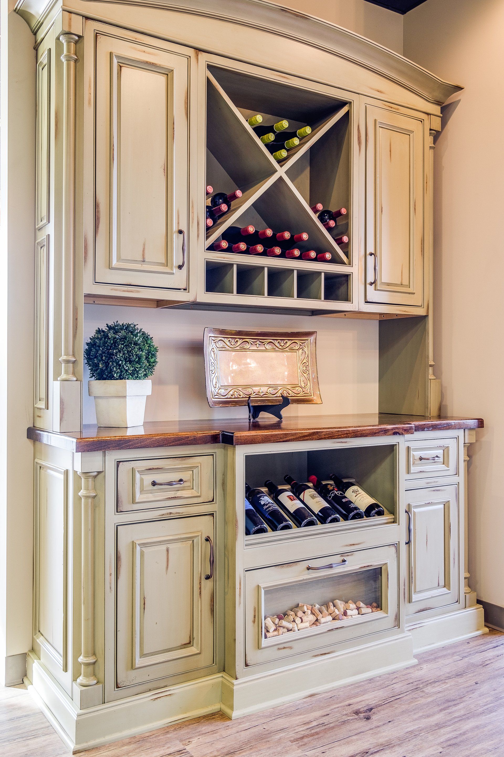 Built-in cream wine cabinet with diagonal bottle racks and glass-front storage in a home dining area