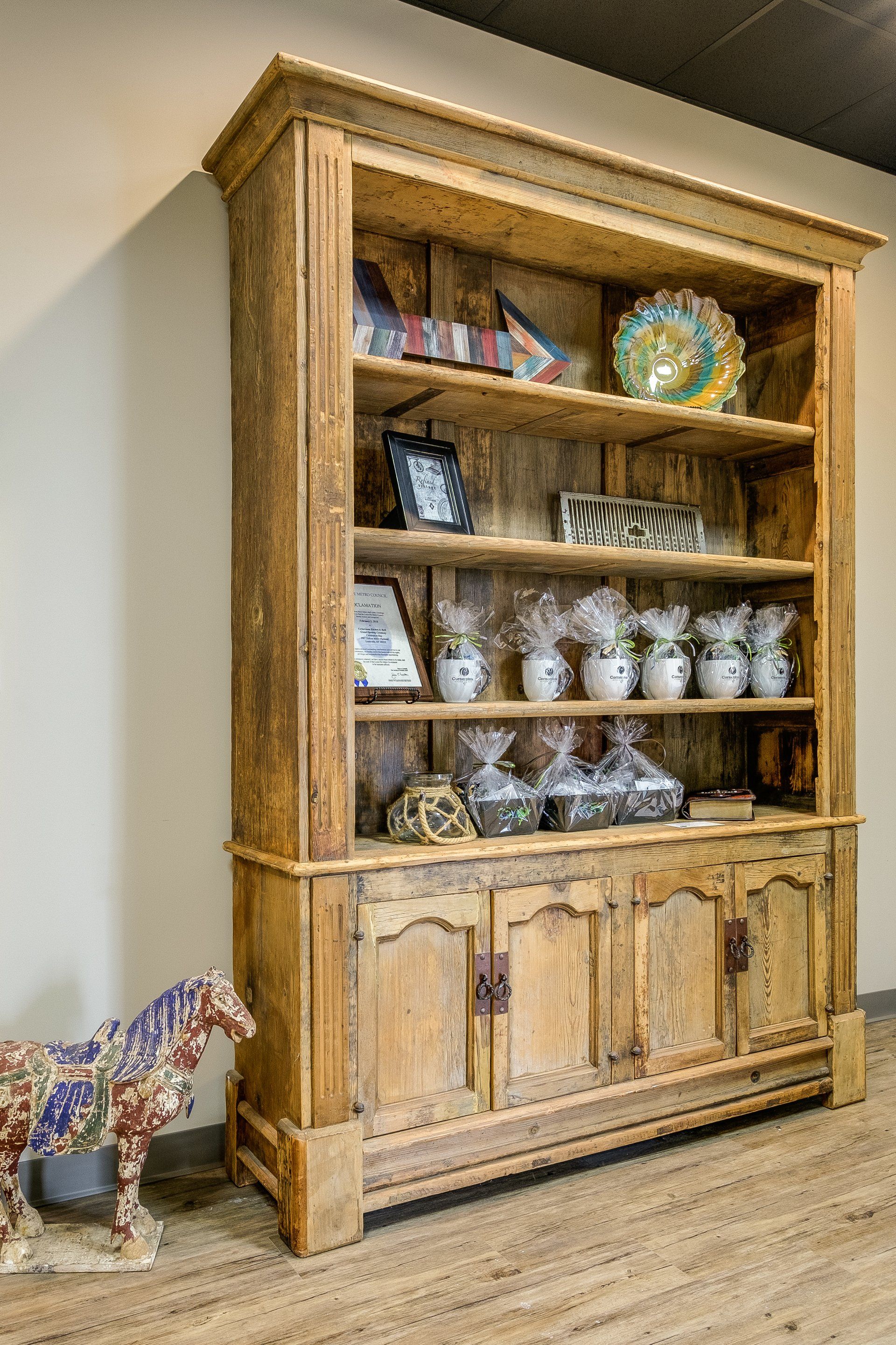 Wooden hutch with dishes and decor in a room with wood floors