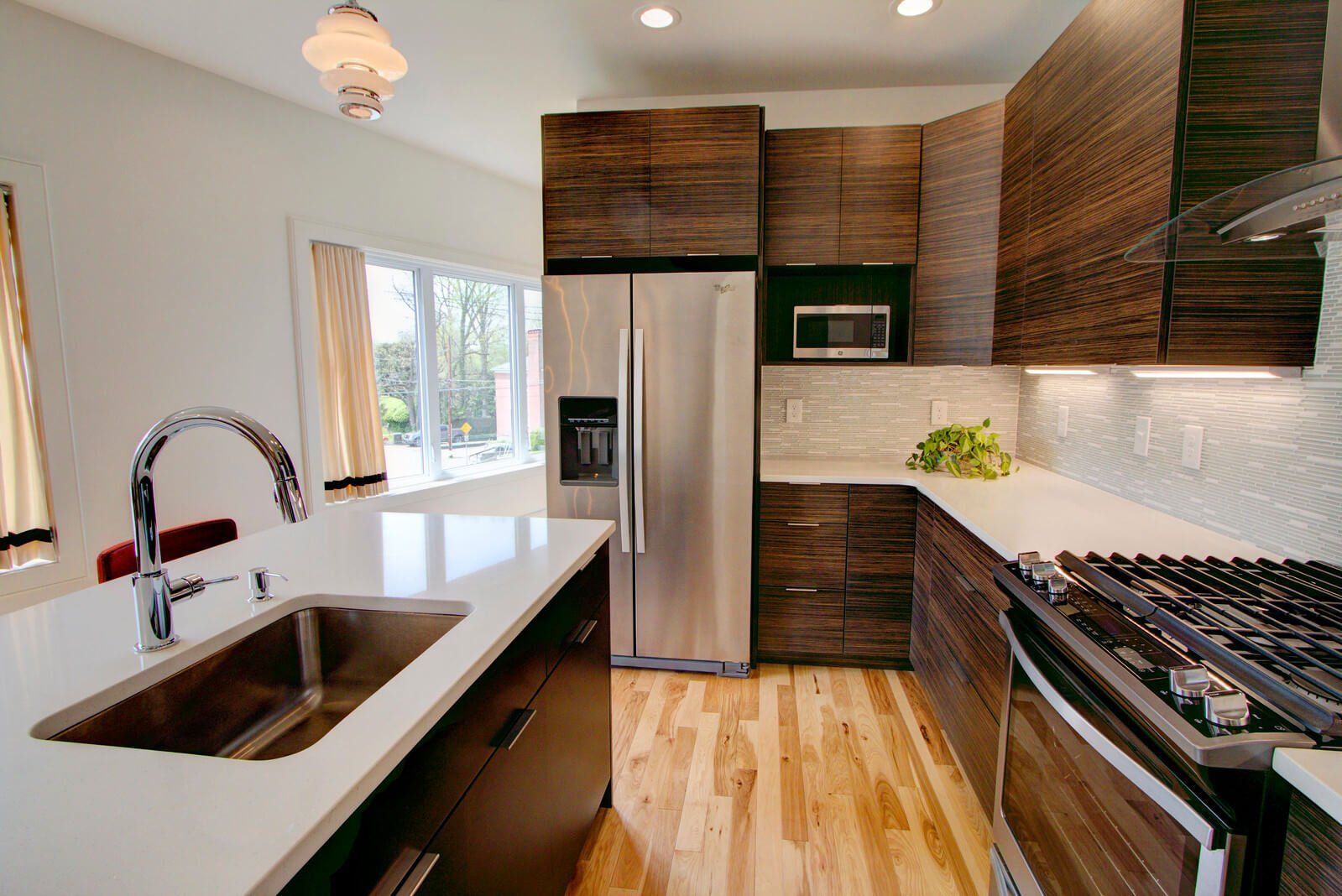 Modern kitchen with wood cabinets, stainless steel appliances, and a black countertop island