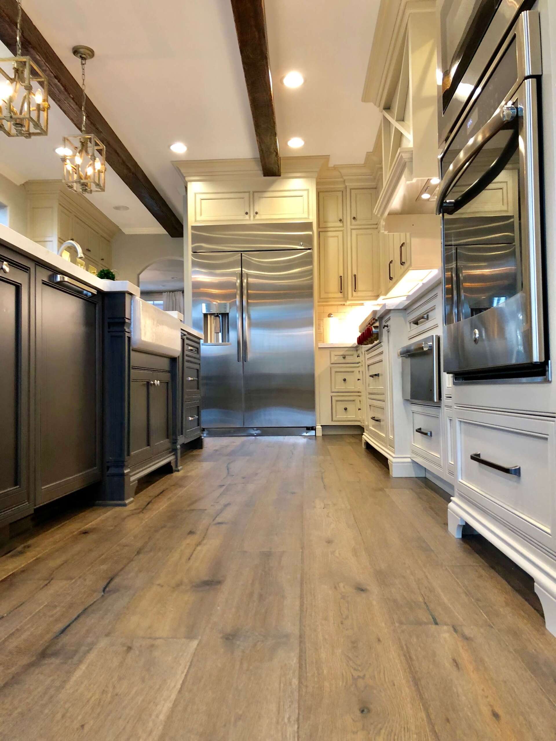 Bright modern kitchen with stainless steel appliances, white cabinetry, and wood floors