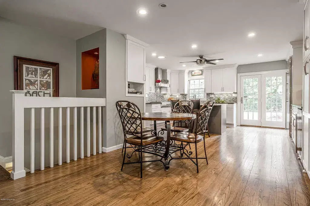 Bright open dining and living area with wood floors, table and chairs, and sliding glass doors to outside