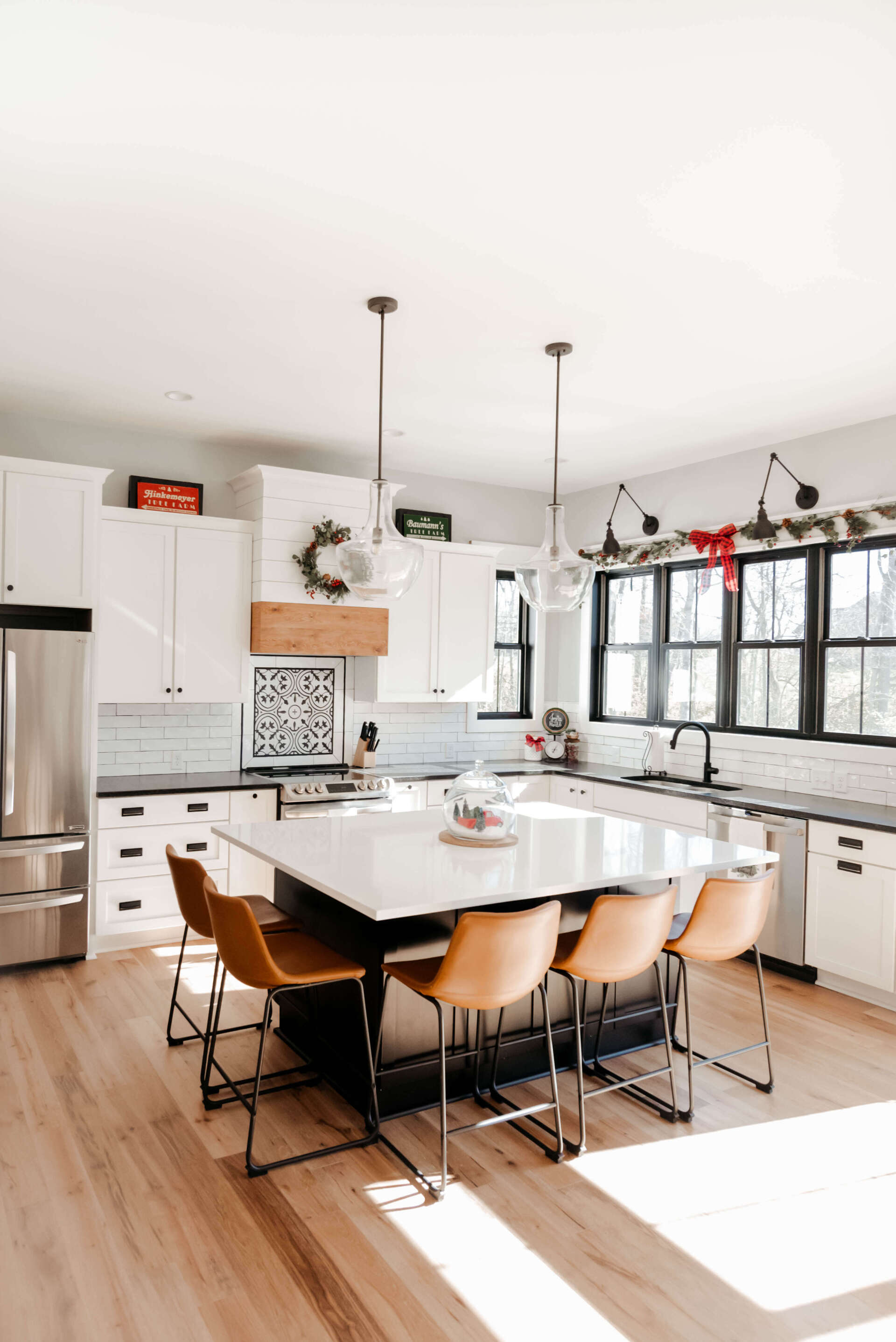 Bright modern kitchen with white cabinets, large island, and dining stools in natural light