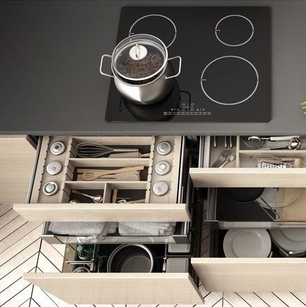 Modern kitchen with black cooktop, pot, and open drawers showing organized cookware and utensils