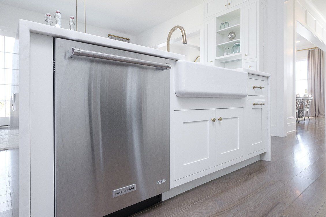Modern white kitchen with stainless dishwasher and sink area