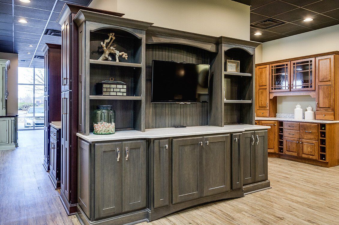Custom gray built-in entertainment center with TV in a showroom kitchen display