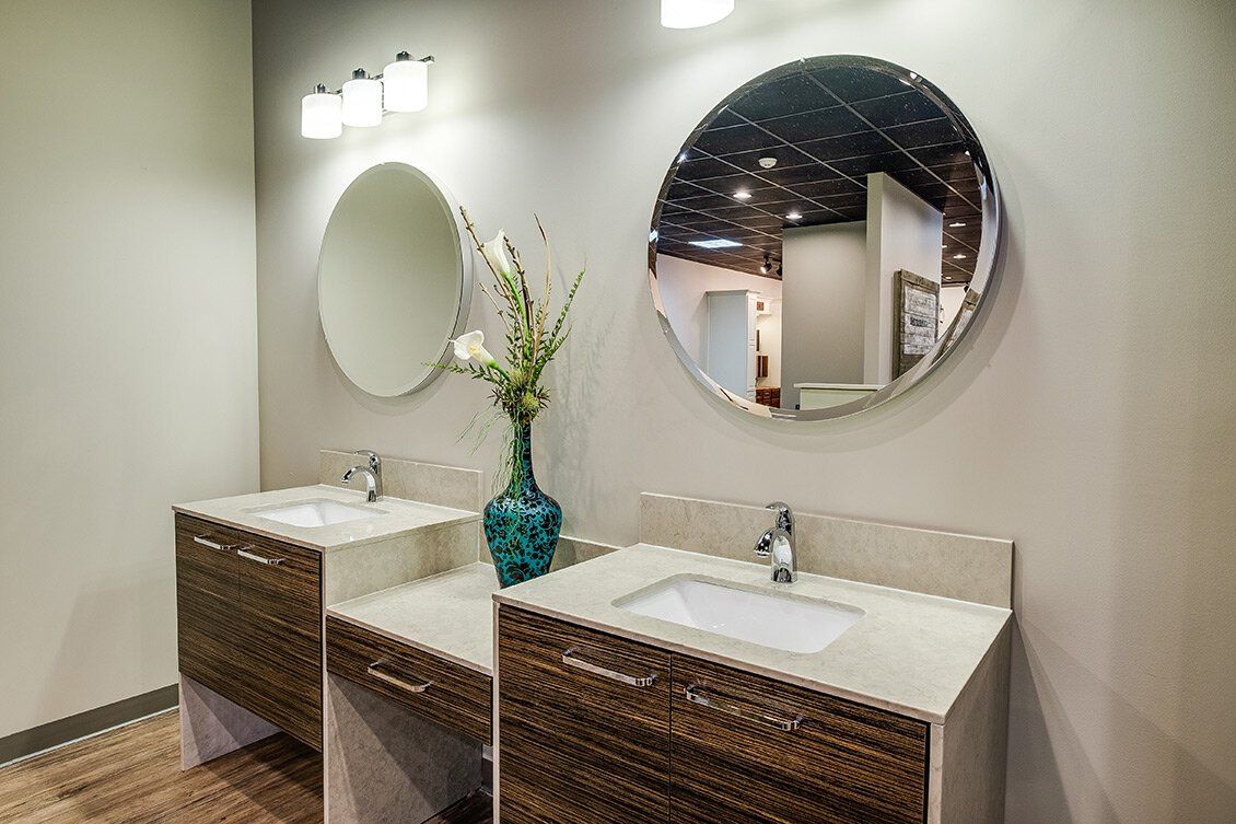 Modern bathroom vanity with two sinks, round mirrors, and wicker-front cabinets under soft lighting