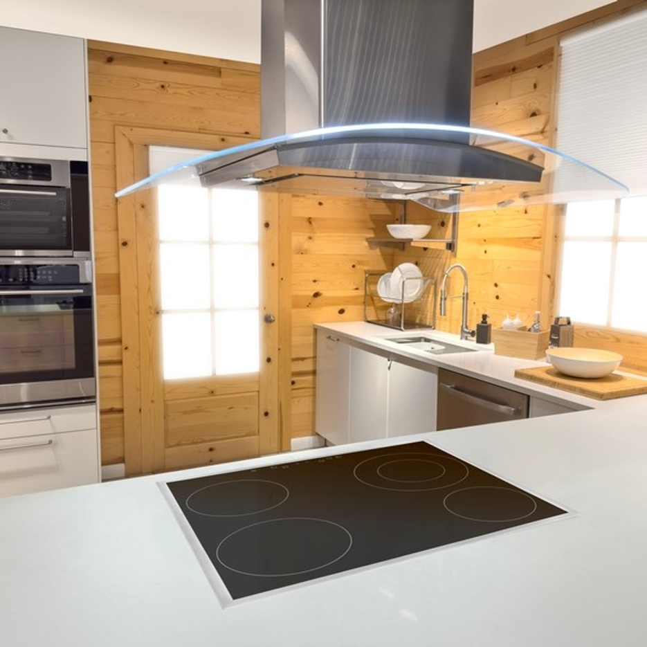 Modern kitchen with island cooktop, white cabinets, wood walls, and stainless steel range hood