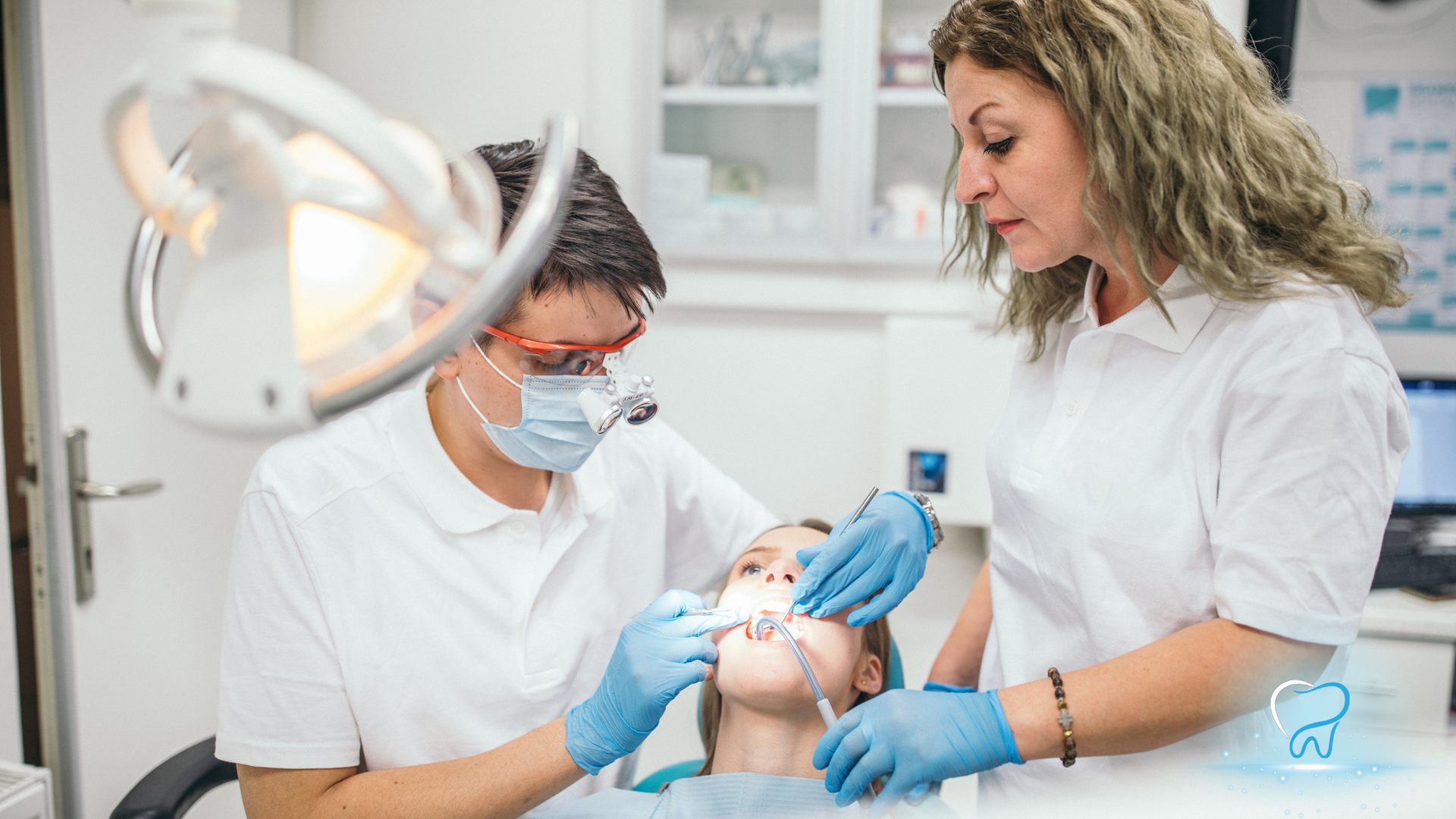 Dentist and assistant treating a child in a bright dental clinic, wearing gloves and masks