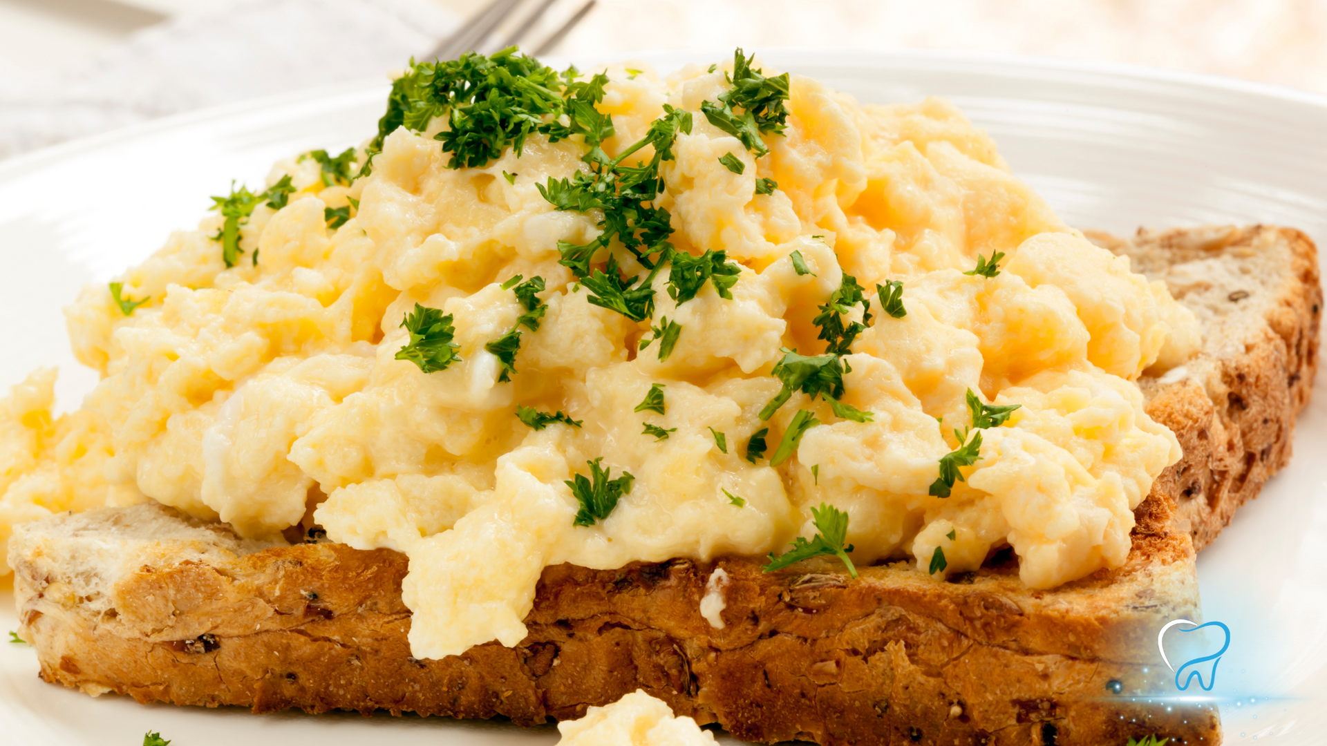 Scrambled eggs with parsley on toast on a white plate