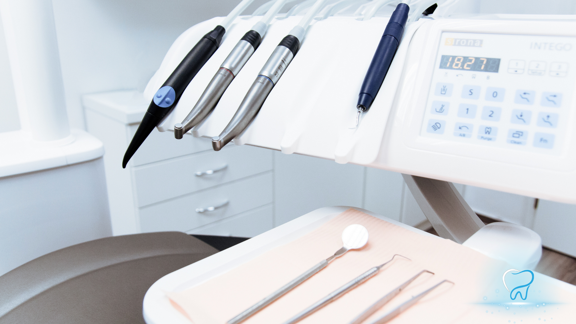 Dentist chair and dental tools in a clean, modern clinic with a control panel and instrument tray