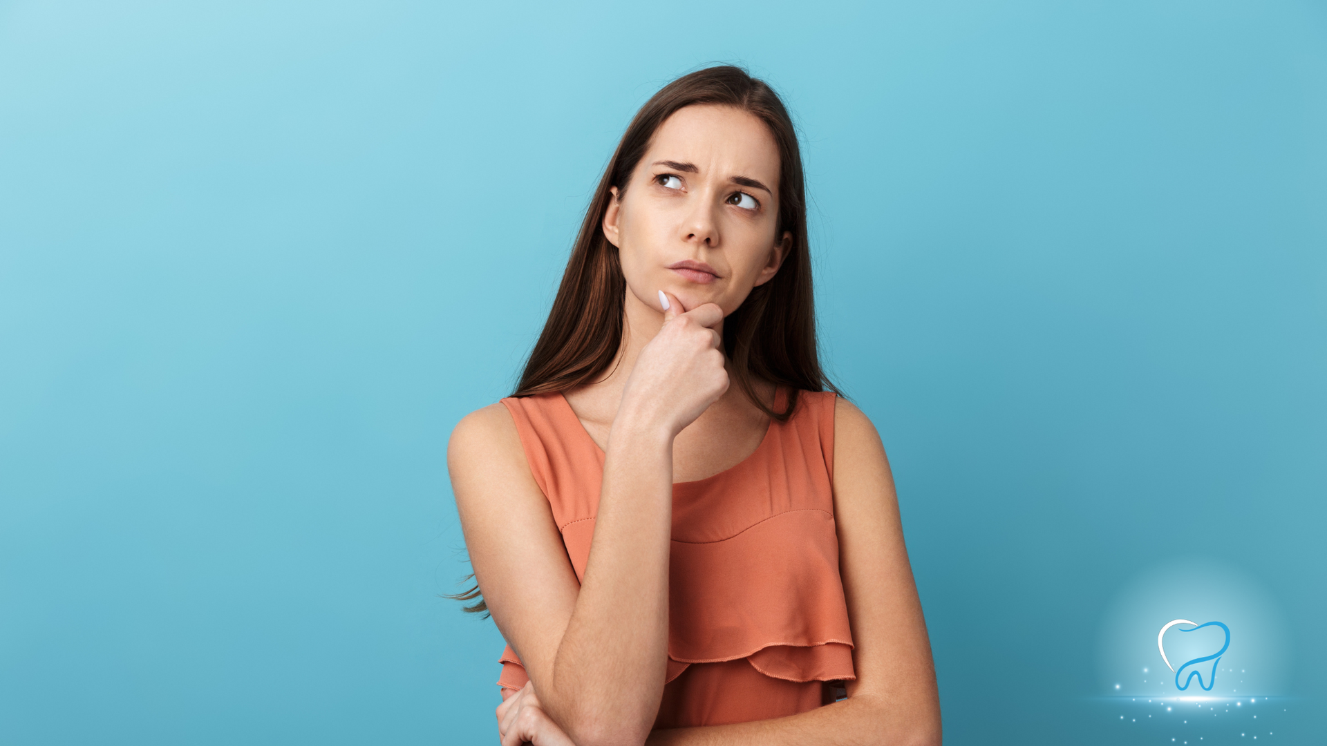 Woman in an orange top thinking against a blue background