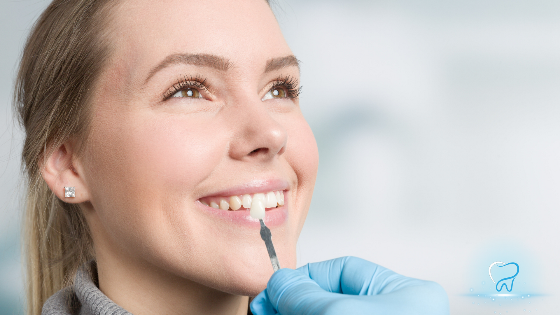Woman smiling while dentist applies a dental tool to her teeth