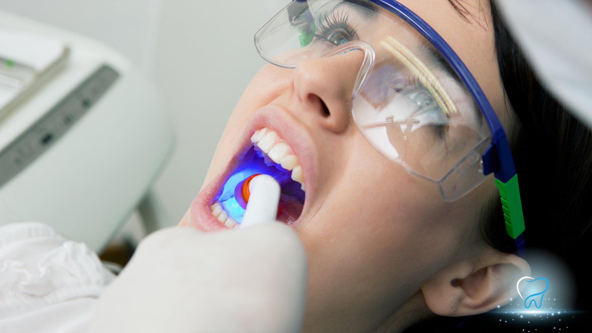 Person wearing protective glasses receiving blue light dental treatment in a clinic
