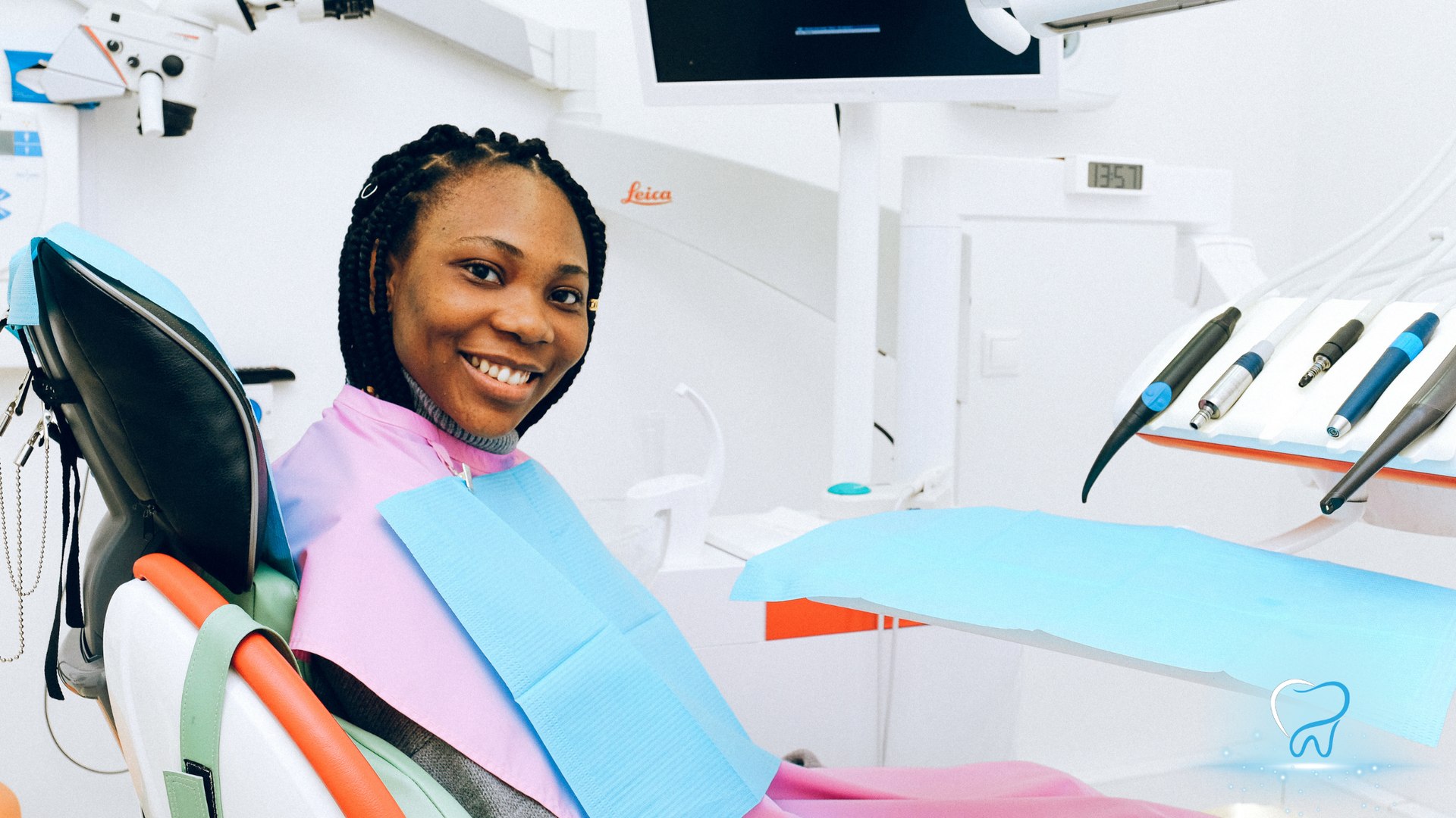 Woman smiling in a dental chair during a checkup, with blue bib and dental tools nearby