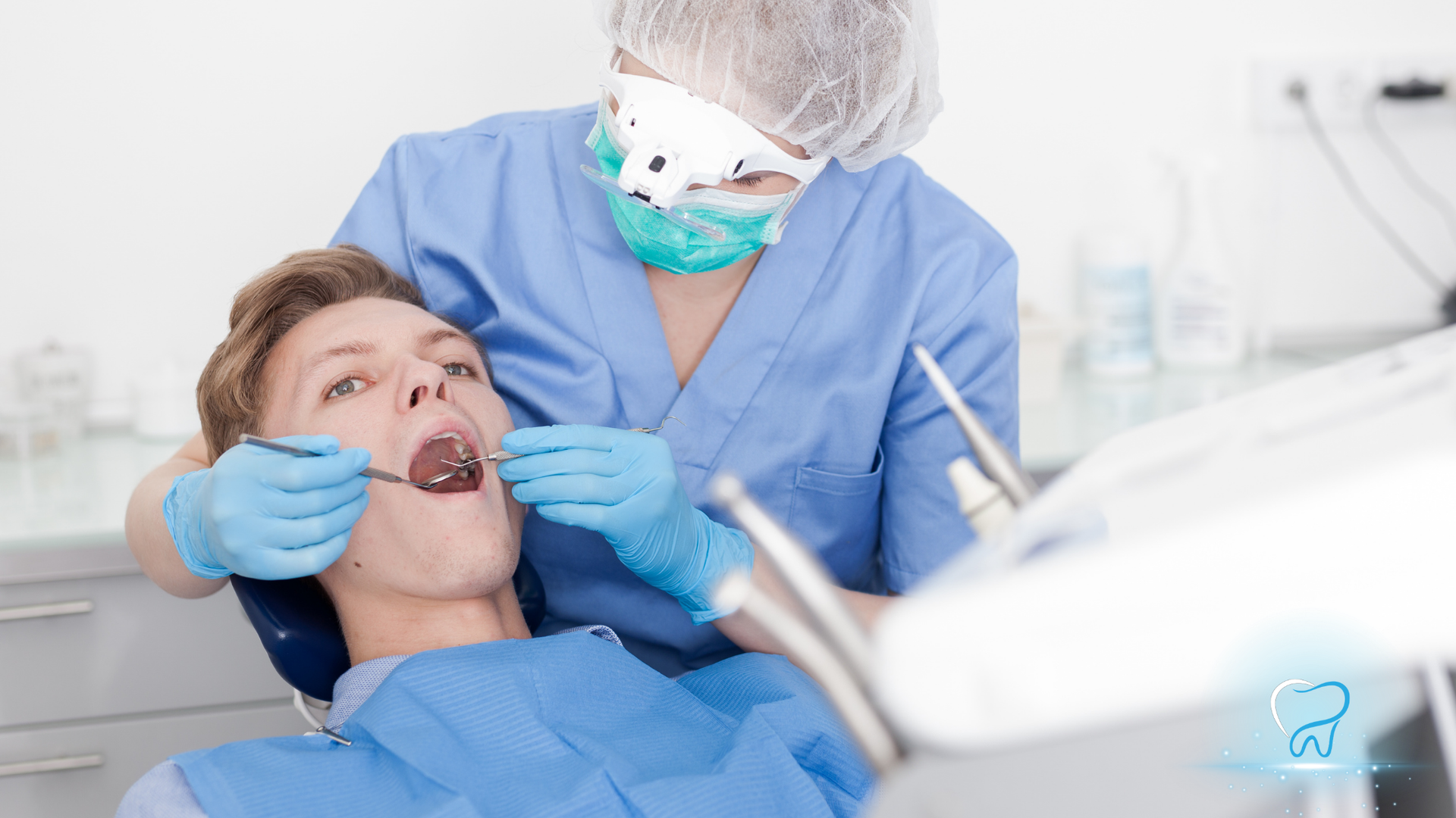 Dentist examining a patient in a dental chair with blue gloves and a mask in a bright clinic.
