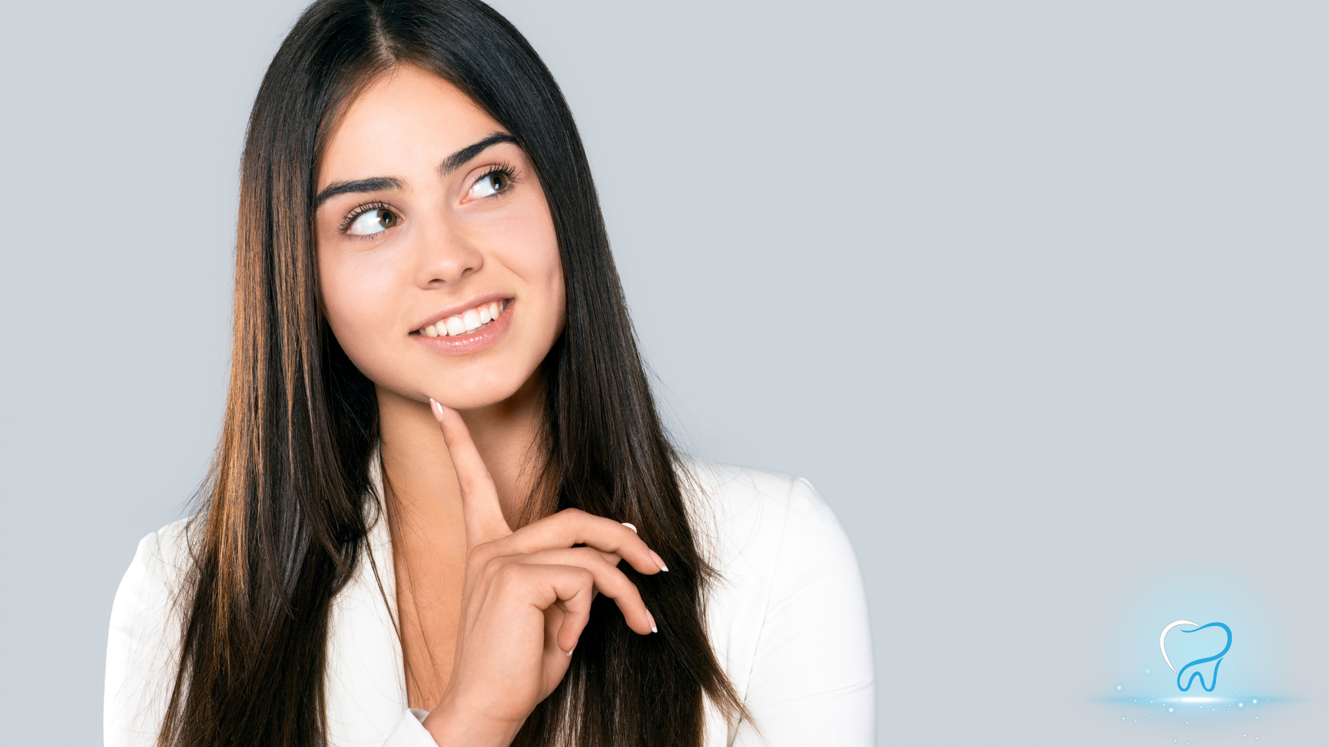 Smiling woman in a white shirt looking up thoughtfully against a light gray background