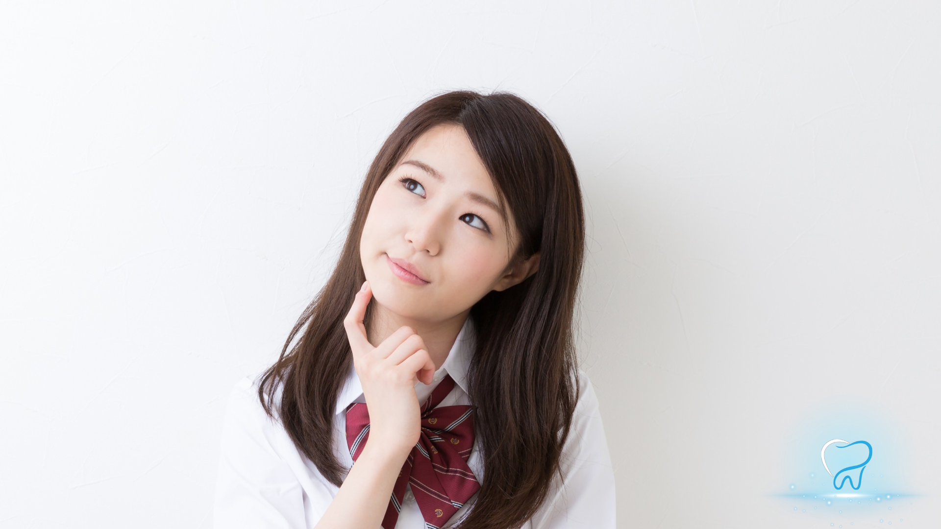 Young woman in a white blouse and red tie, posing thoughtfully against a white background.