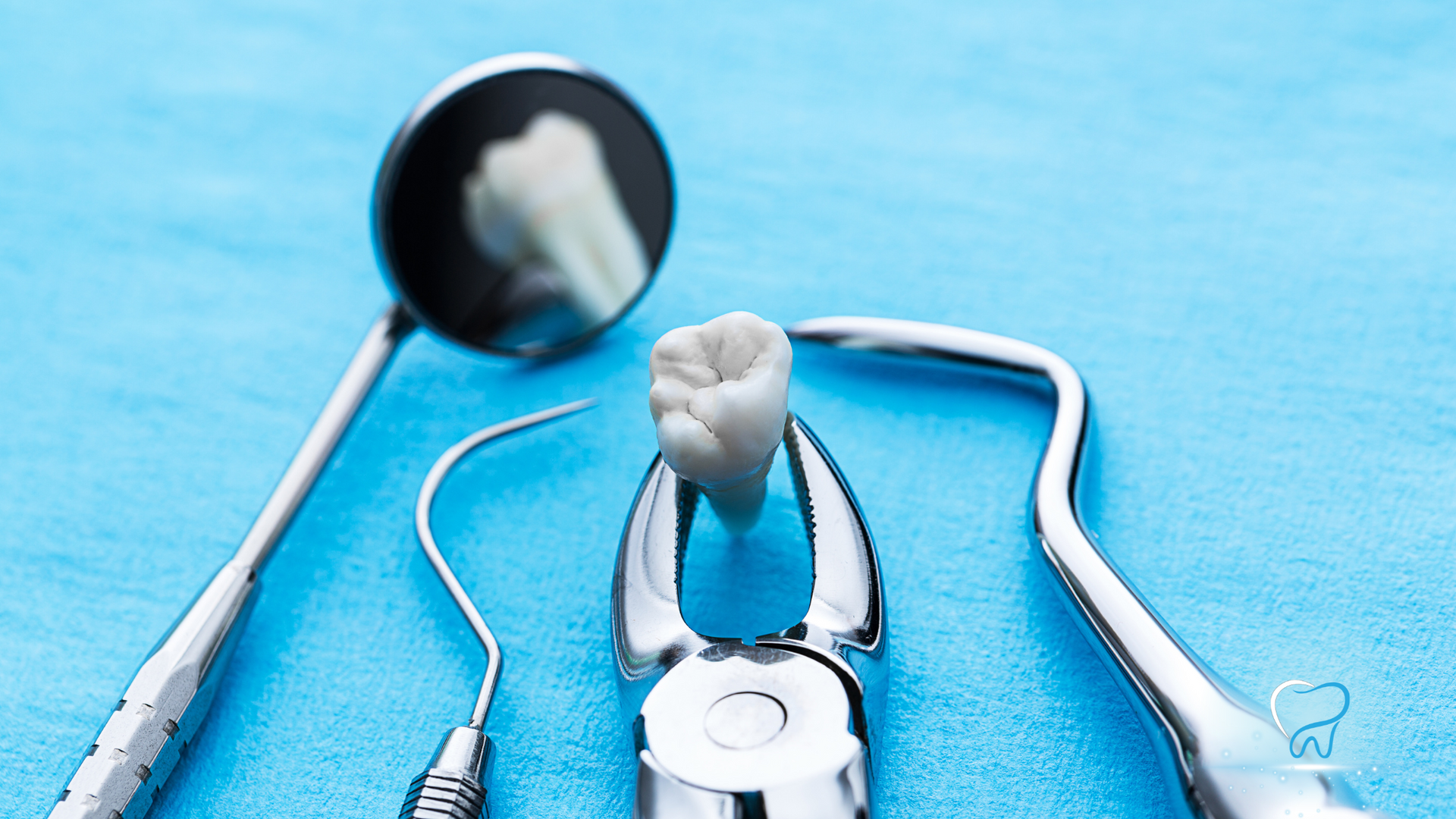 Dental mirror and tooth model on a blue background, representing dental care and examination
