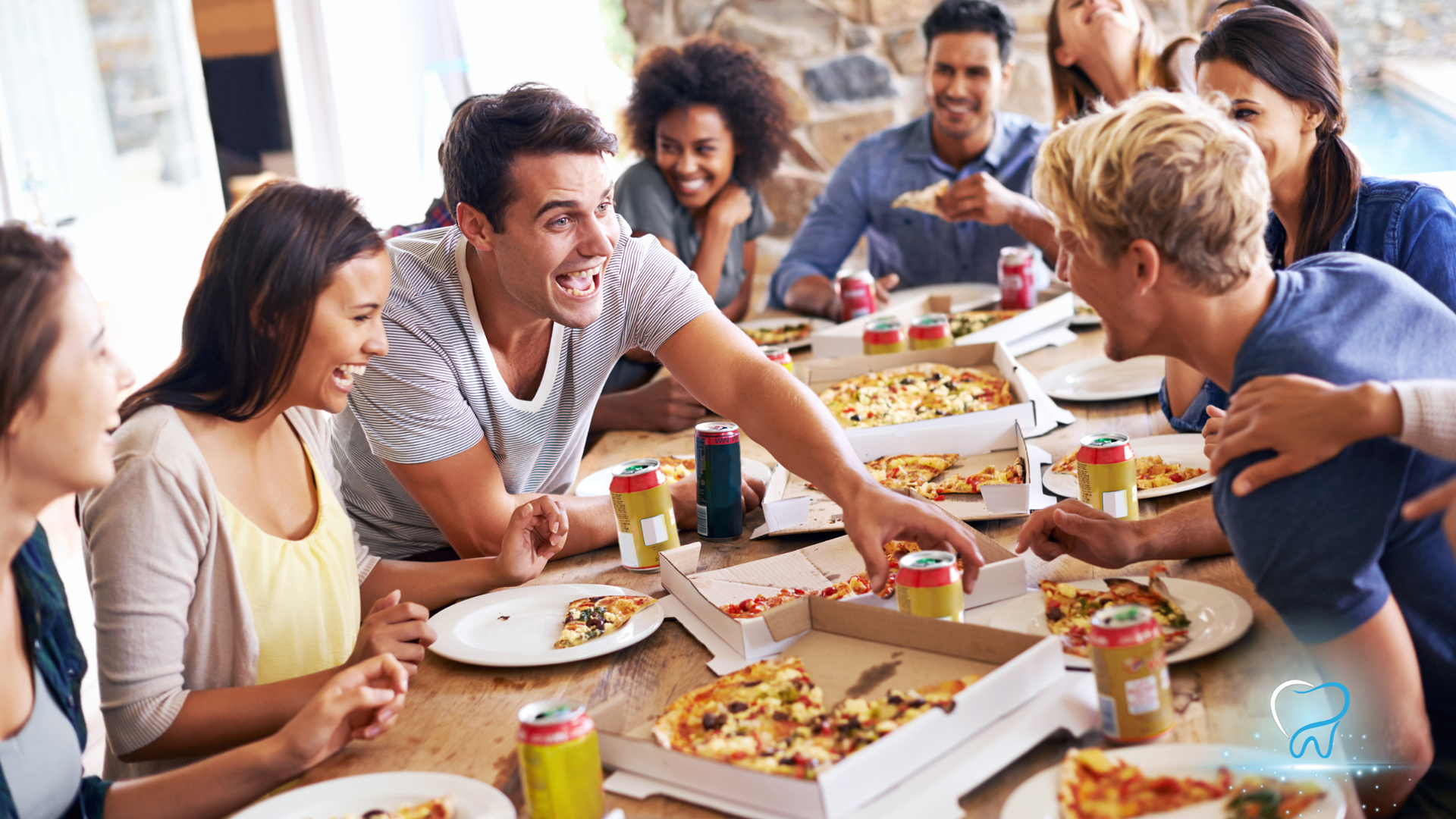 Friends sharing pizza and conversation at a lively dinner table outdoors