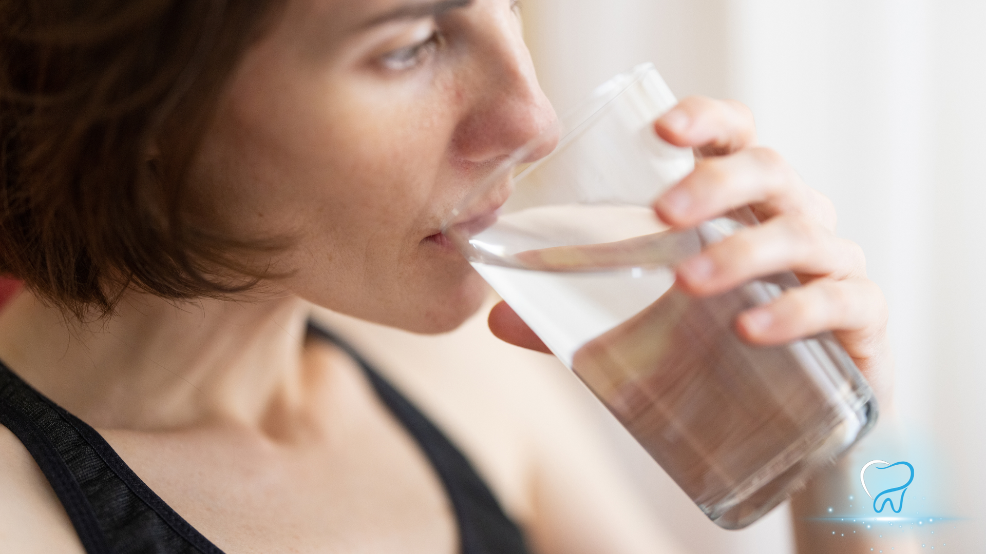 Woman drinking a glass of water, close-up side view