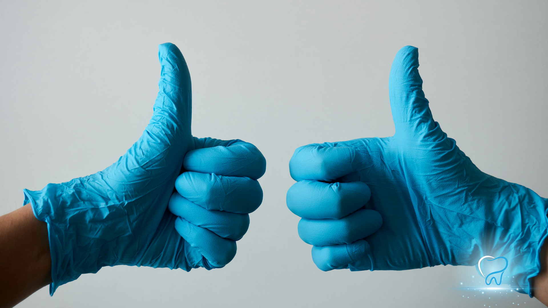 Two blue-gloved hands giving thumbs up against a light background