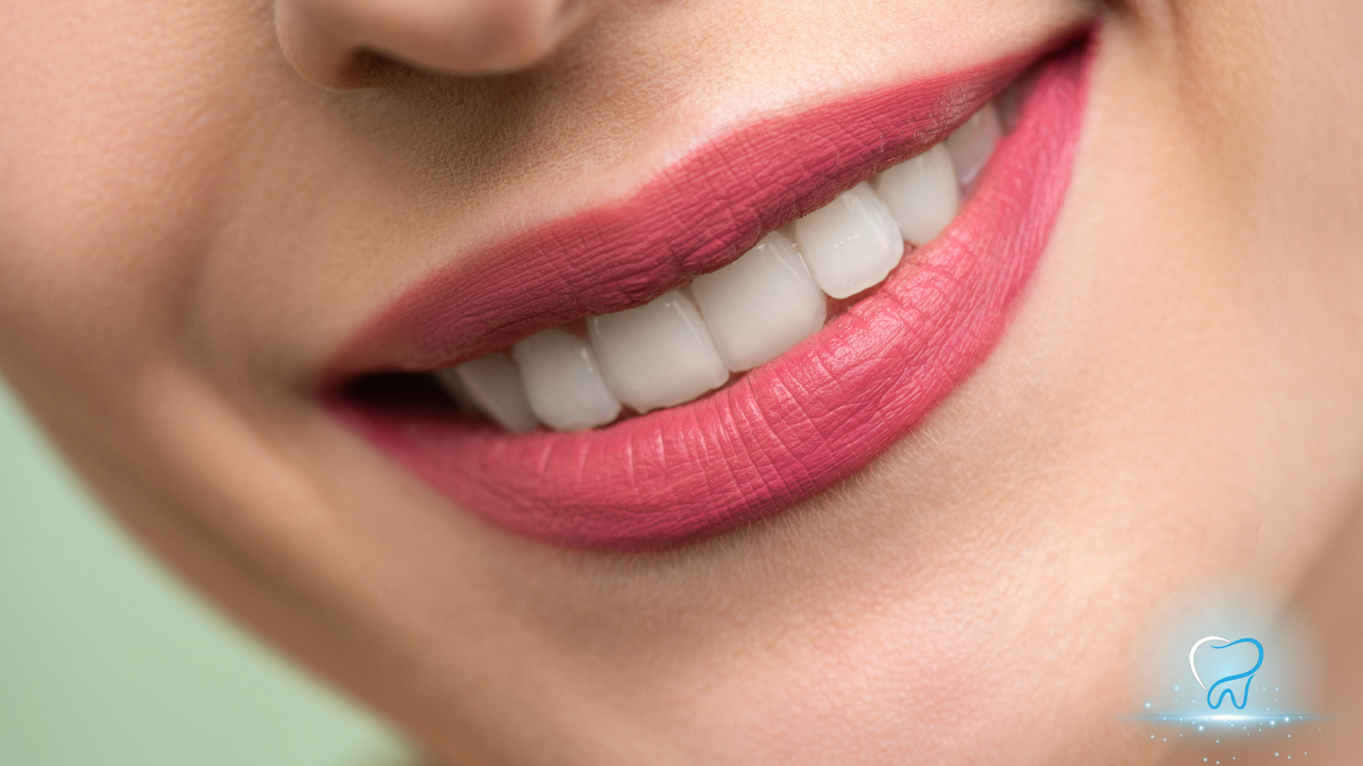 Close-up of a smiling mouth with pink lipstick and white teeth