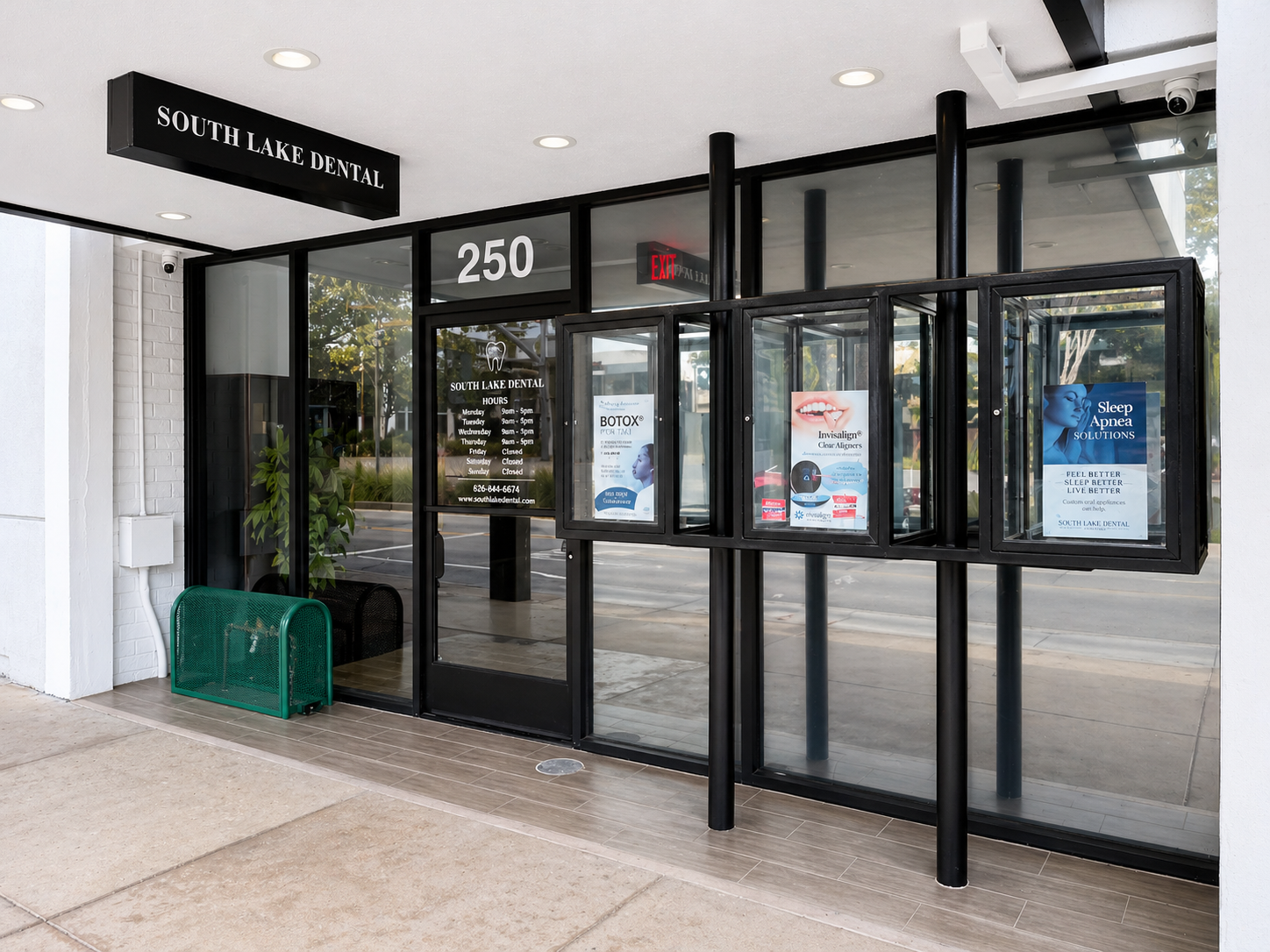 Storefront entrance with glass doors, black framing, address 250, and a green bench outside