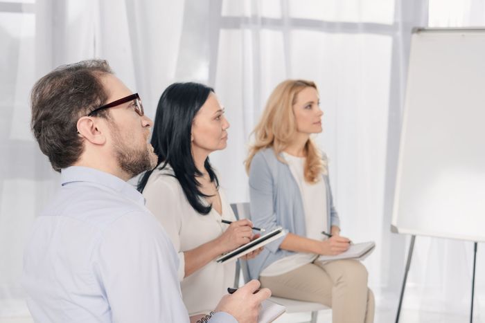 A group of people are sitting in chairs listening to a presentation.