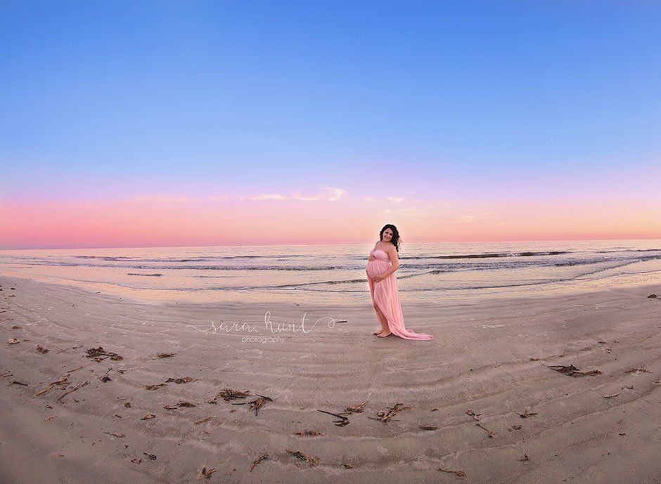 Woman in pink dress holding her tummy — Pearland, TX — Sara Hunt Photography