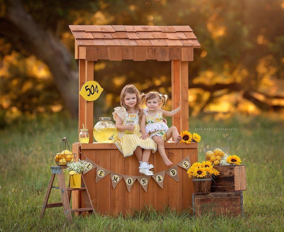 Sisters smiling on lemon stand — Pearland, TX — Sara Hunt Photography