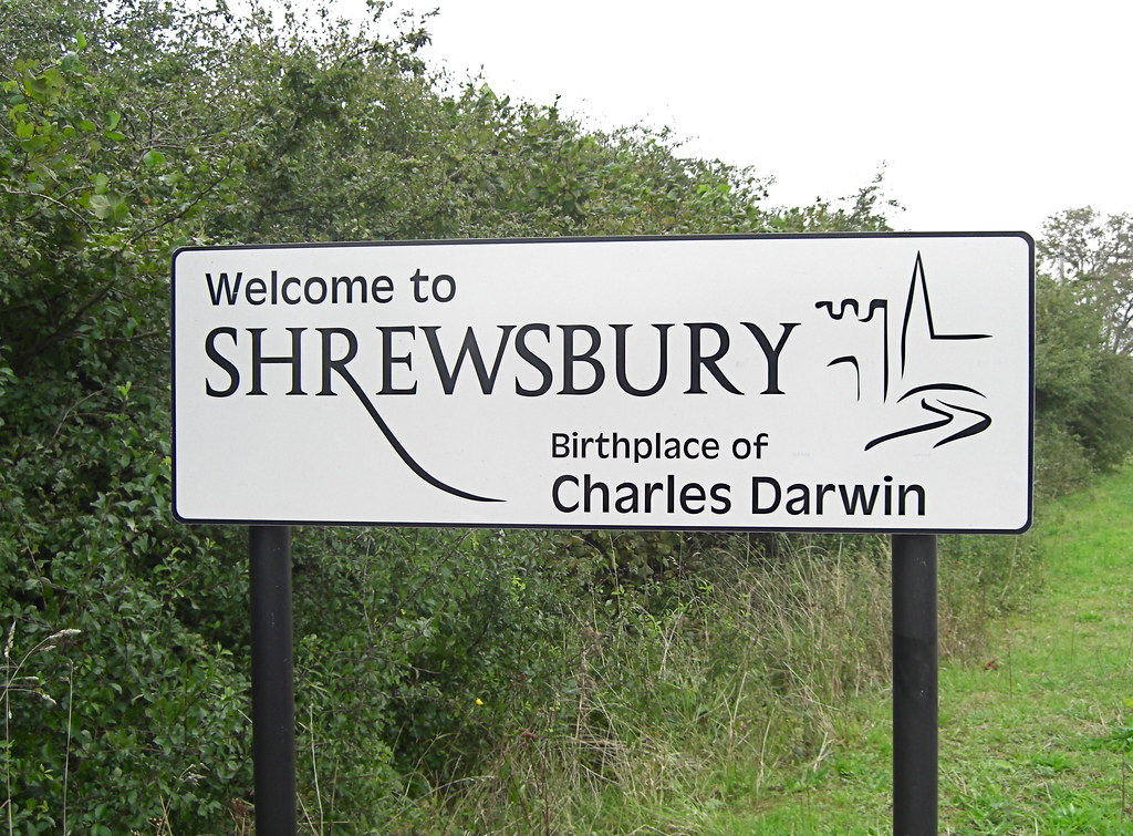 Sign welcoming visitors to Shrewsbury, birthplace of Charles Darwin. White sign on a green background.