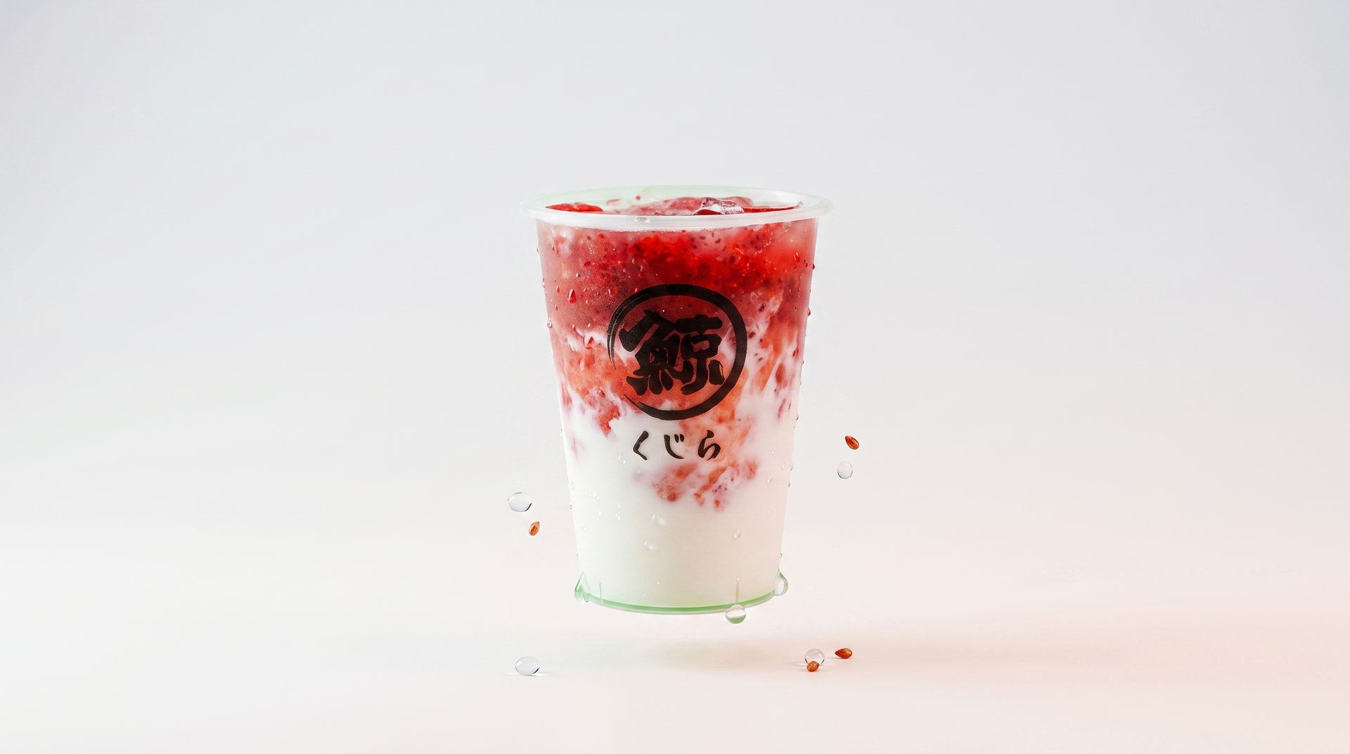 Iced matcha latte with red berry topping in a clear cup on a white background