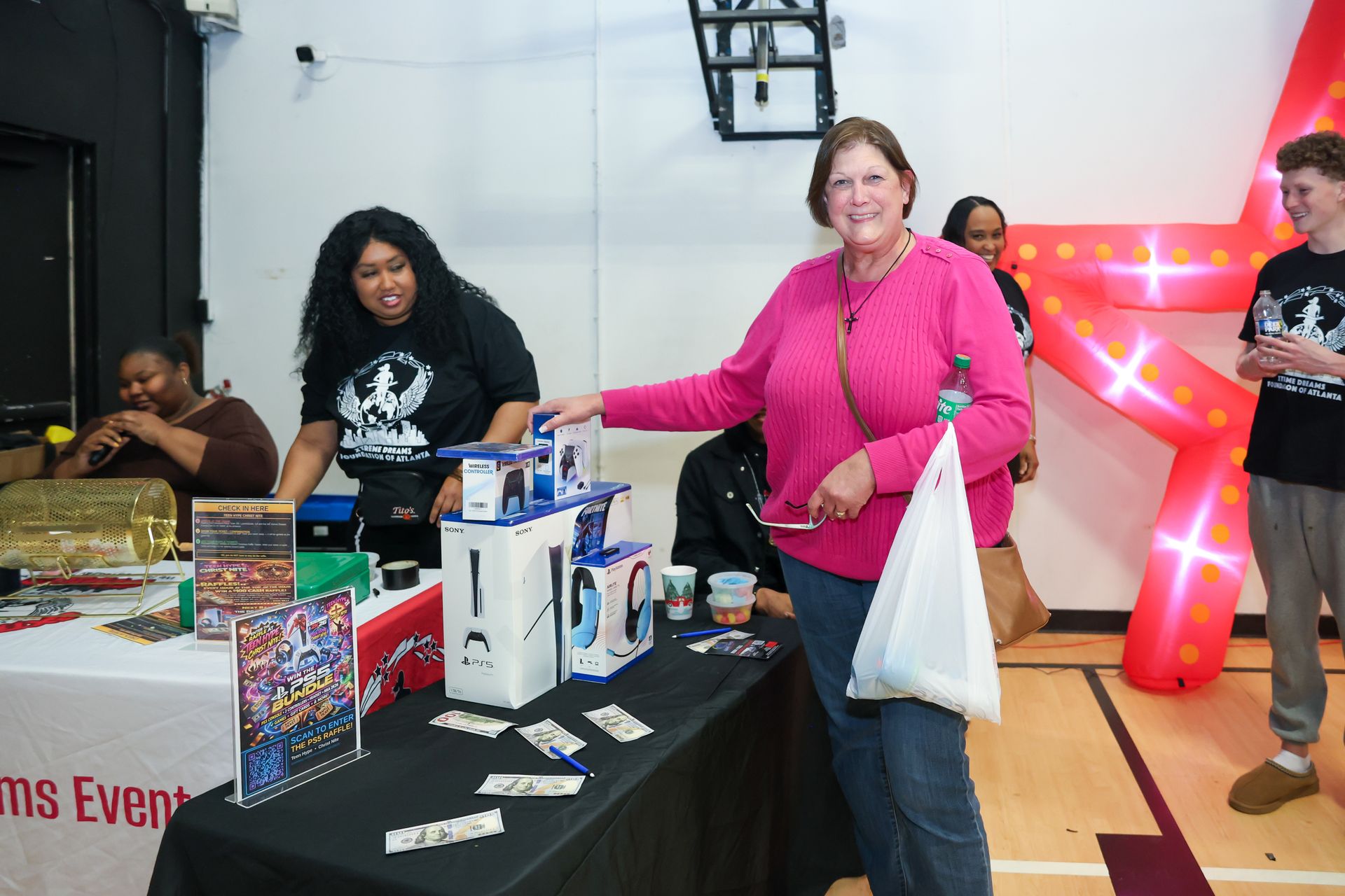 People at a community event table with raffle items and a large red star decoration