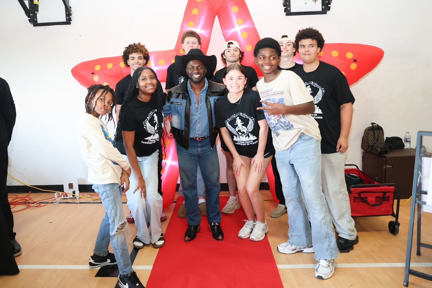 Group of people posing on a red carpet in front of a large red star backdrop