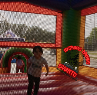 Child in a colorful inflatable bounce house, with a “Extreme Events” logo on the right.