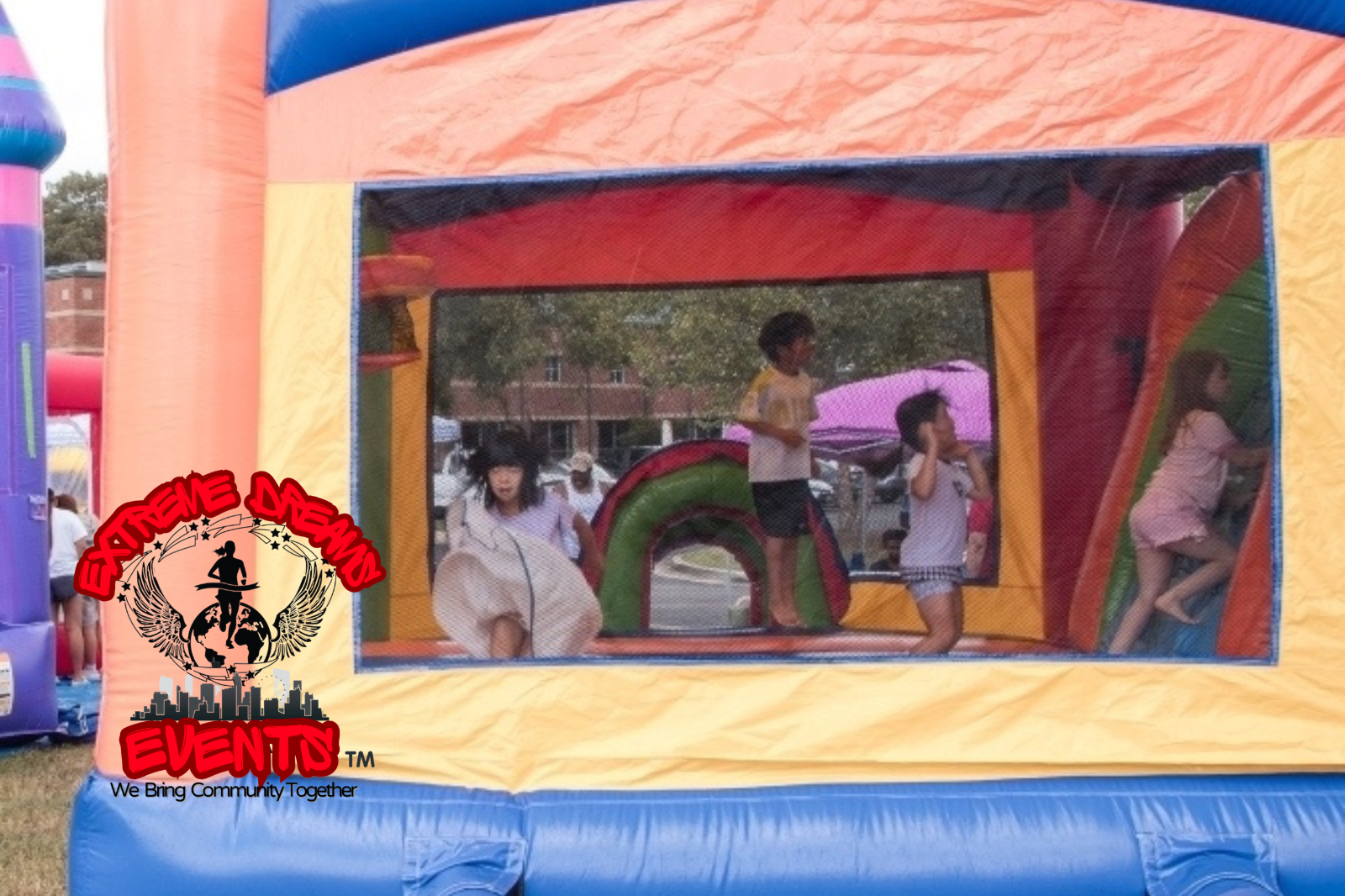 Children playing in a colorful inflatable bounce house with orange, blue, and yellow walls