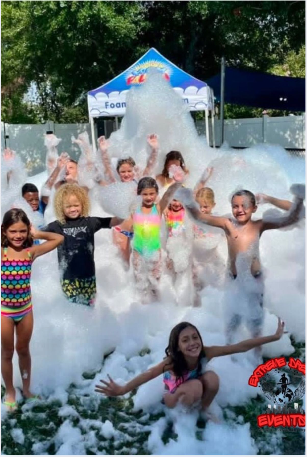 Children playing in a foam-filled outdoor pool at a summer event
