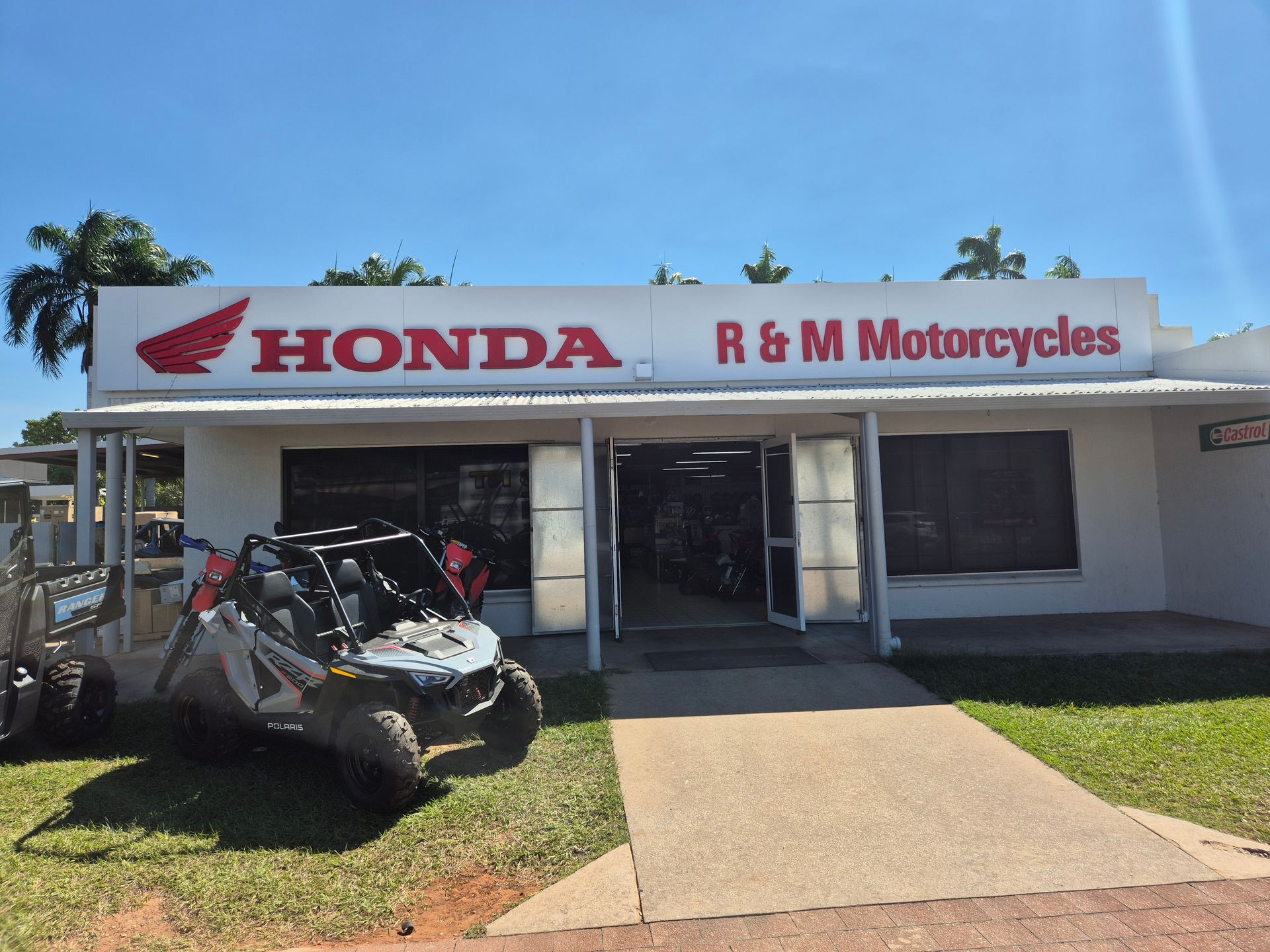 A Man is Loading Rocks Into the Back of a Blue ATV — R & M Motorcycles in Katherine, NT
