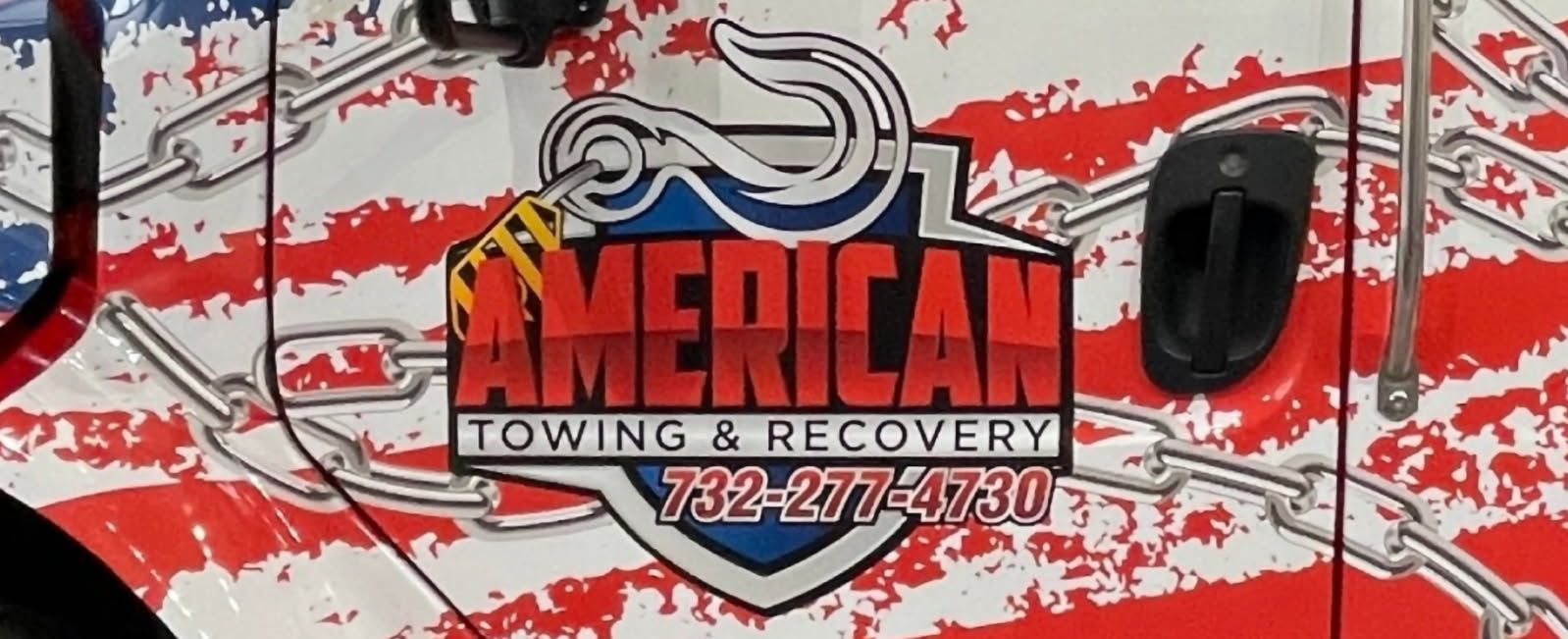 American Towing & Recovery logo on a truck door with an American flag design and the phone number 732-277-4730.