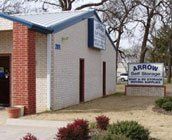 A white building with a blue roof and a sign in front of it. A white building with a blue roof and a sign in front of it.